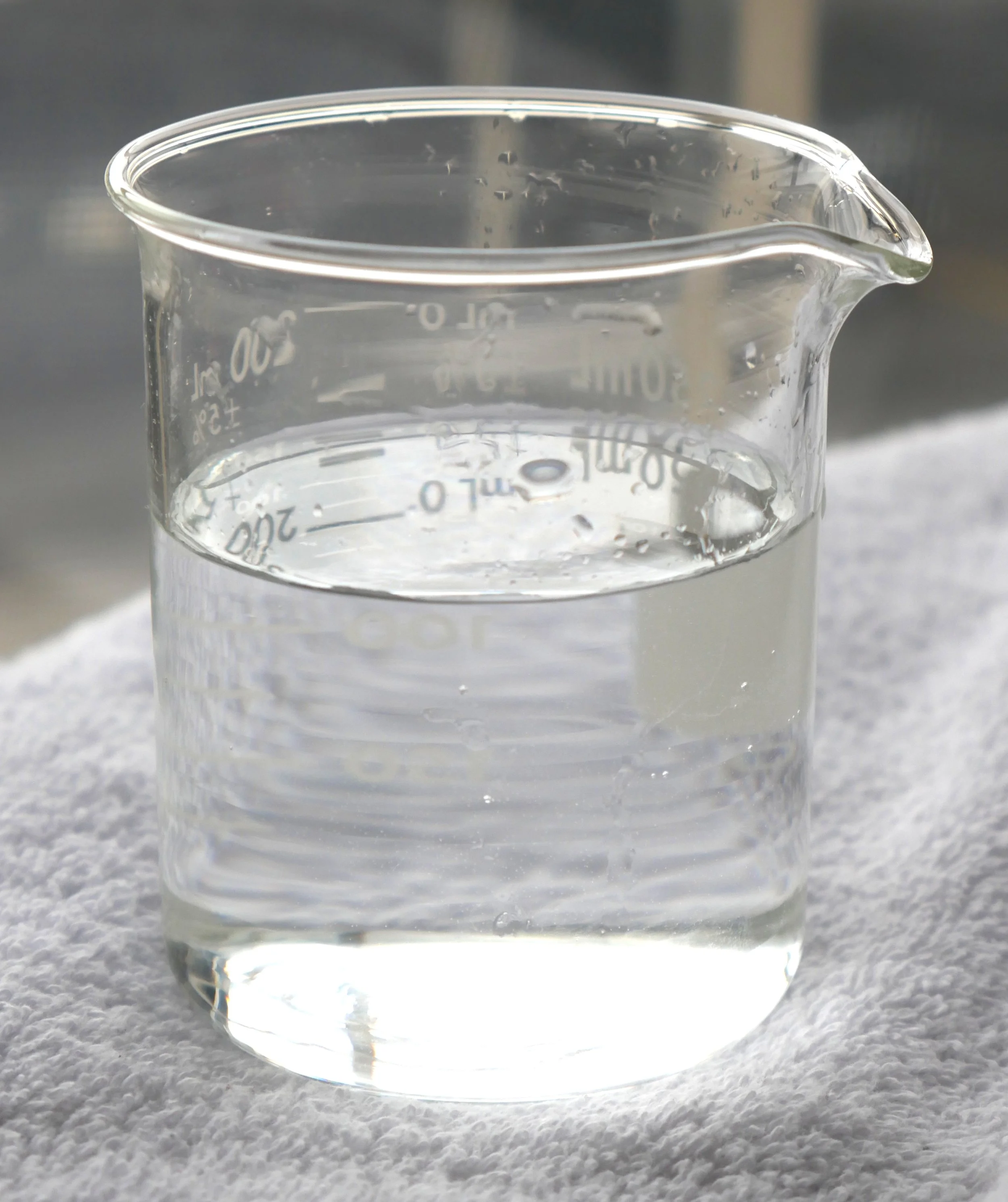 Close-up of bubbles rising in clear water with a metallic background.
