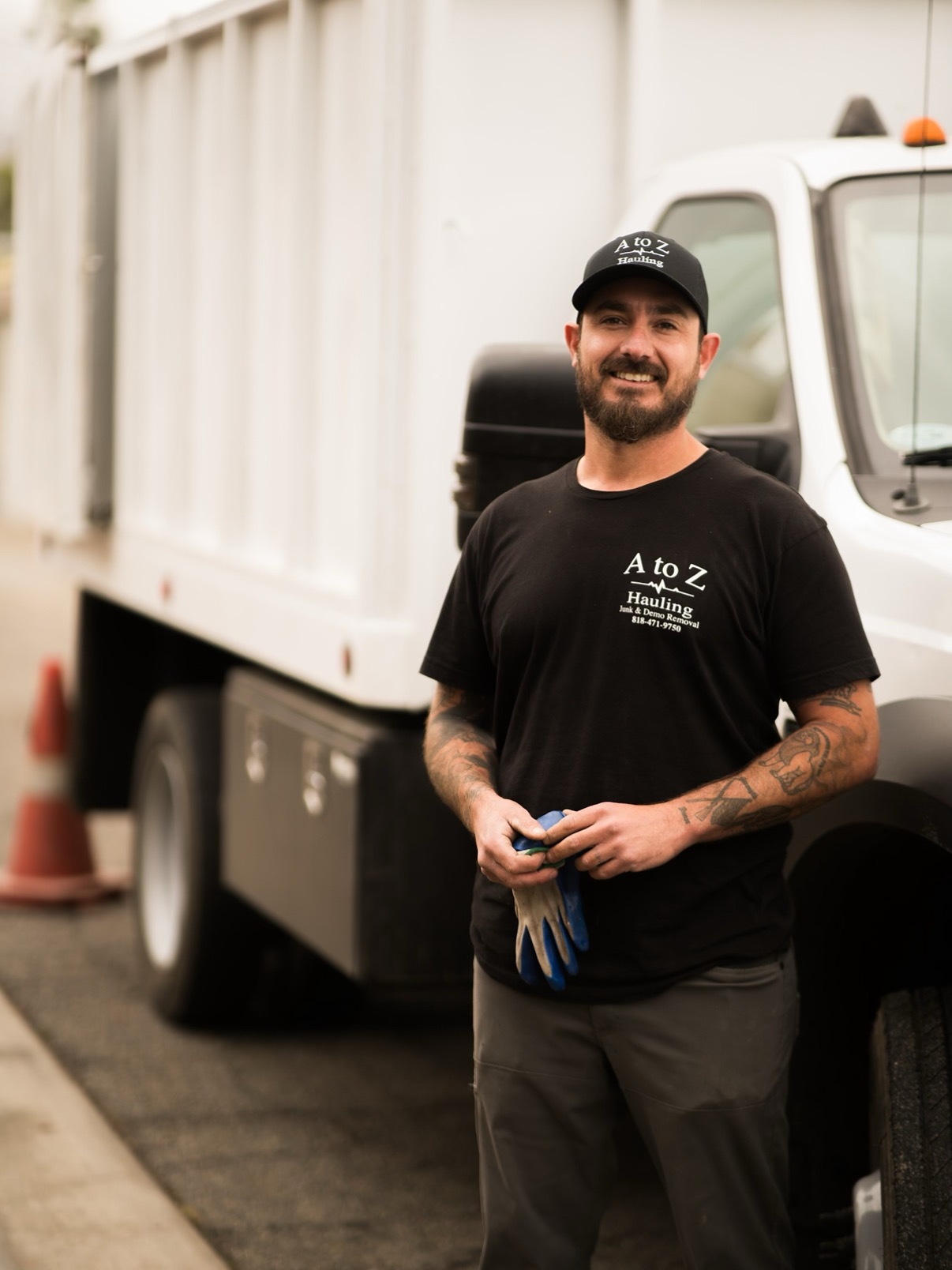 Owner of A to Z Hauling Junk Removal standing by the truck