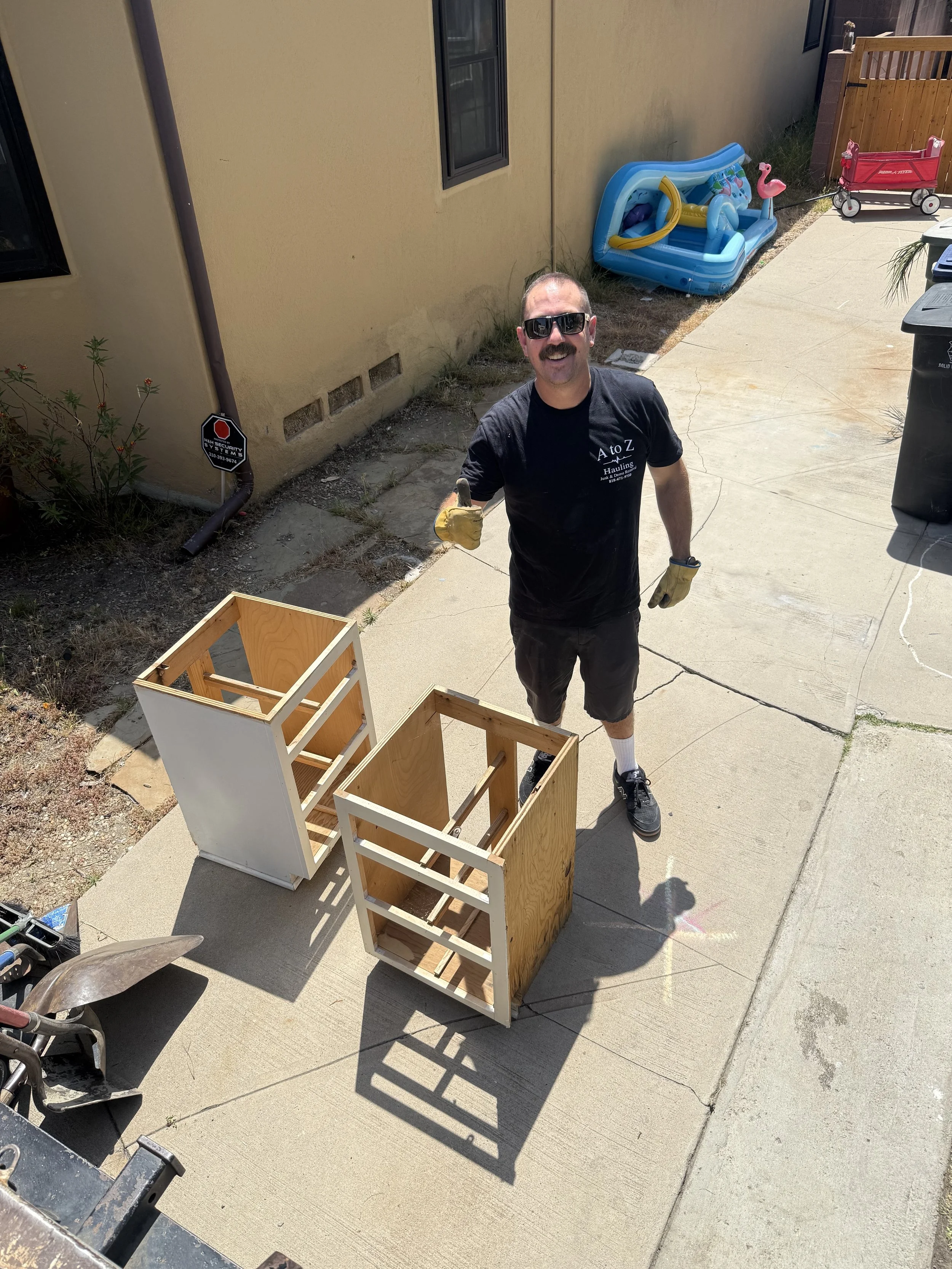 A to Z Hauling crew loading old cabinets during a junk removal pickup in Burbank, CA