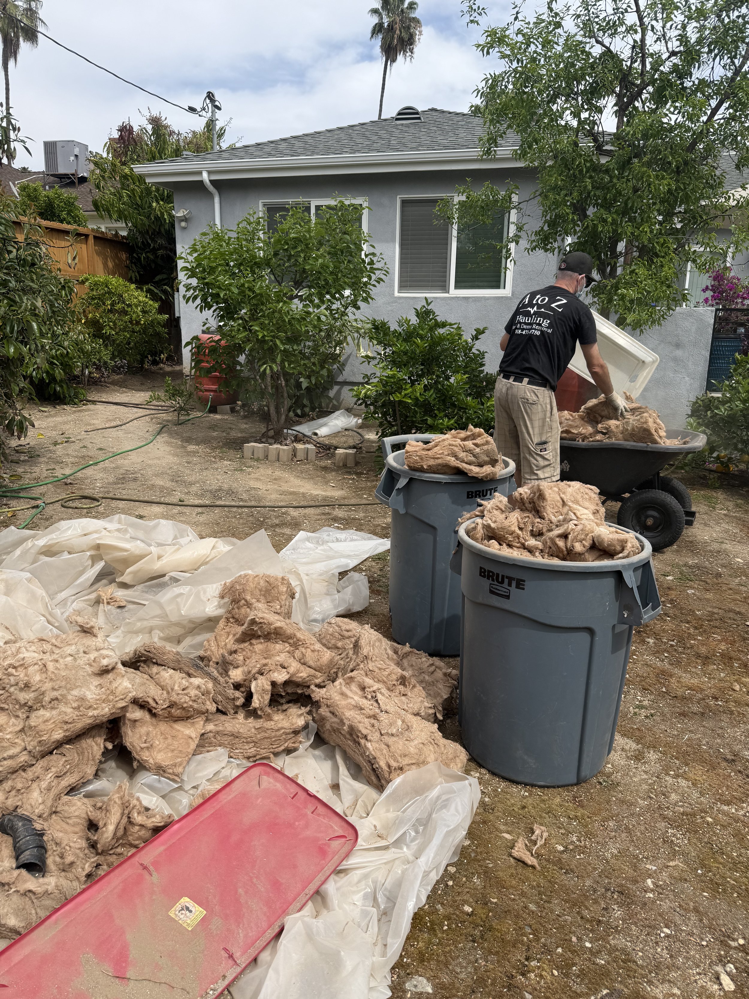 A to Z Hauling Junk Removal crew member in the process of a backyard cleanout