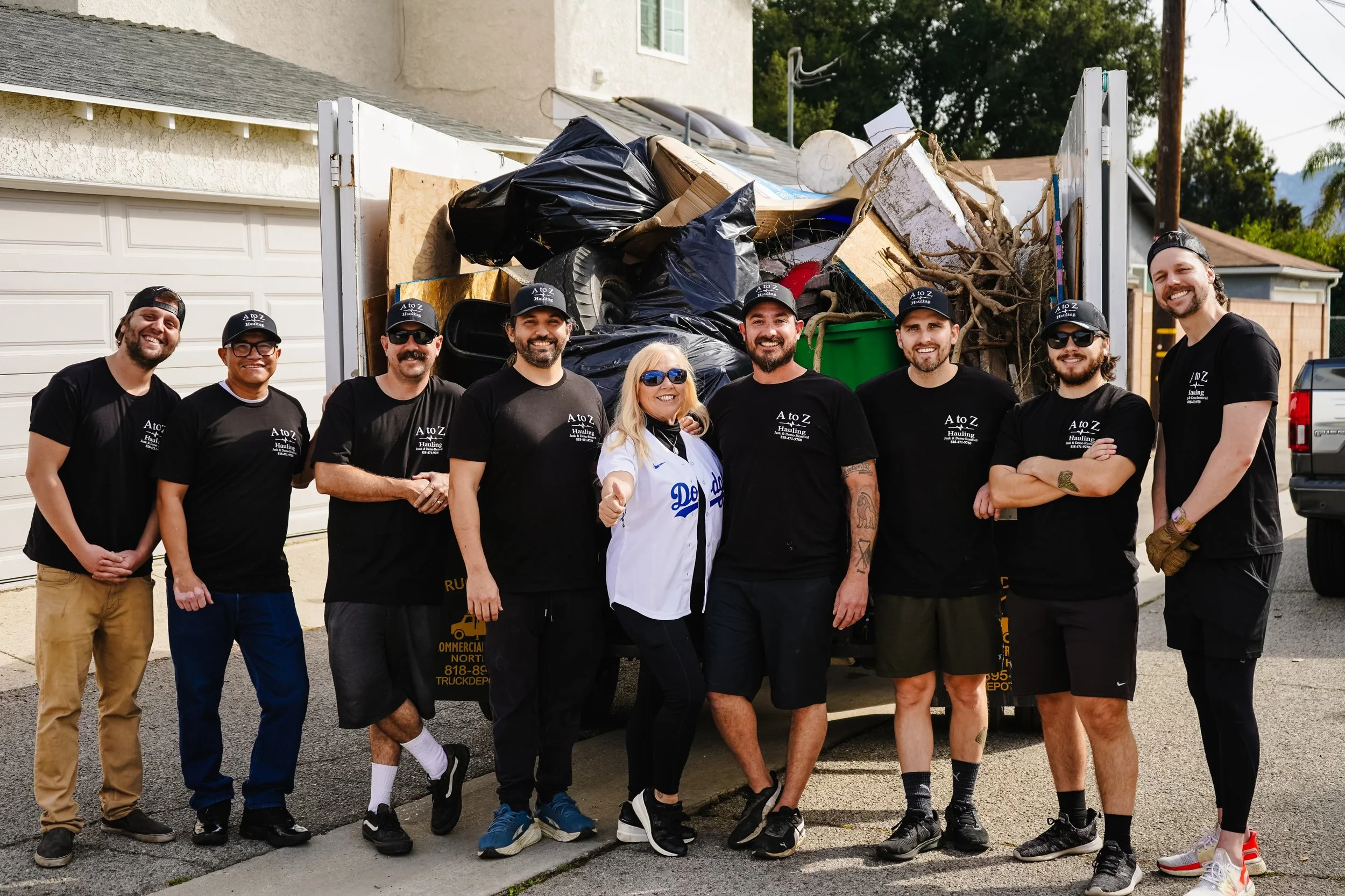 A to Z Hauling crew smiling by the truck on a apartment cleanout