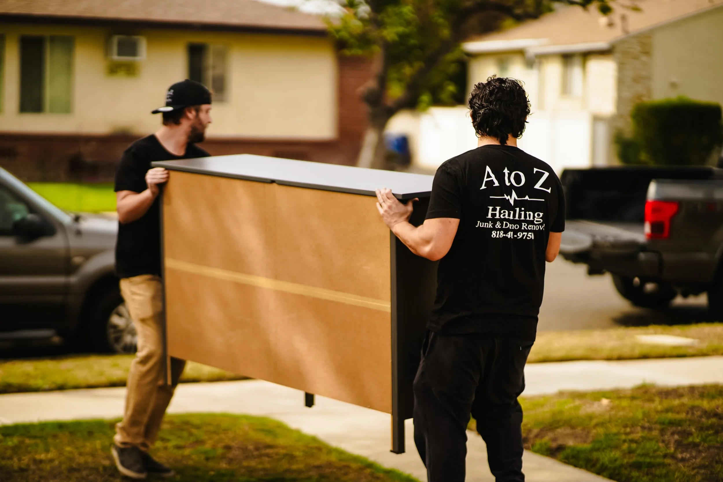 2 A to Z hauling junk removal crew members removing an old dresser in burbank ca