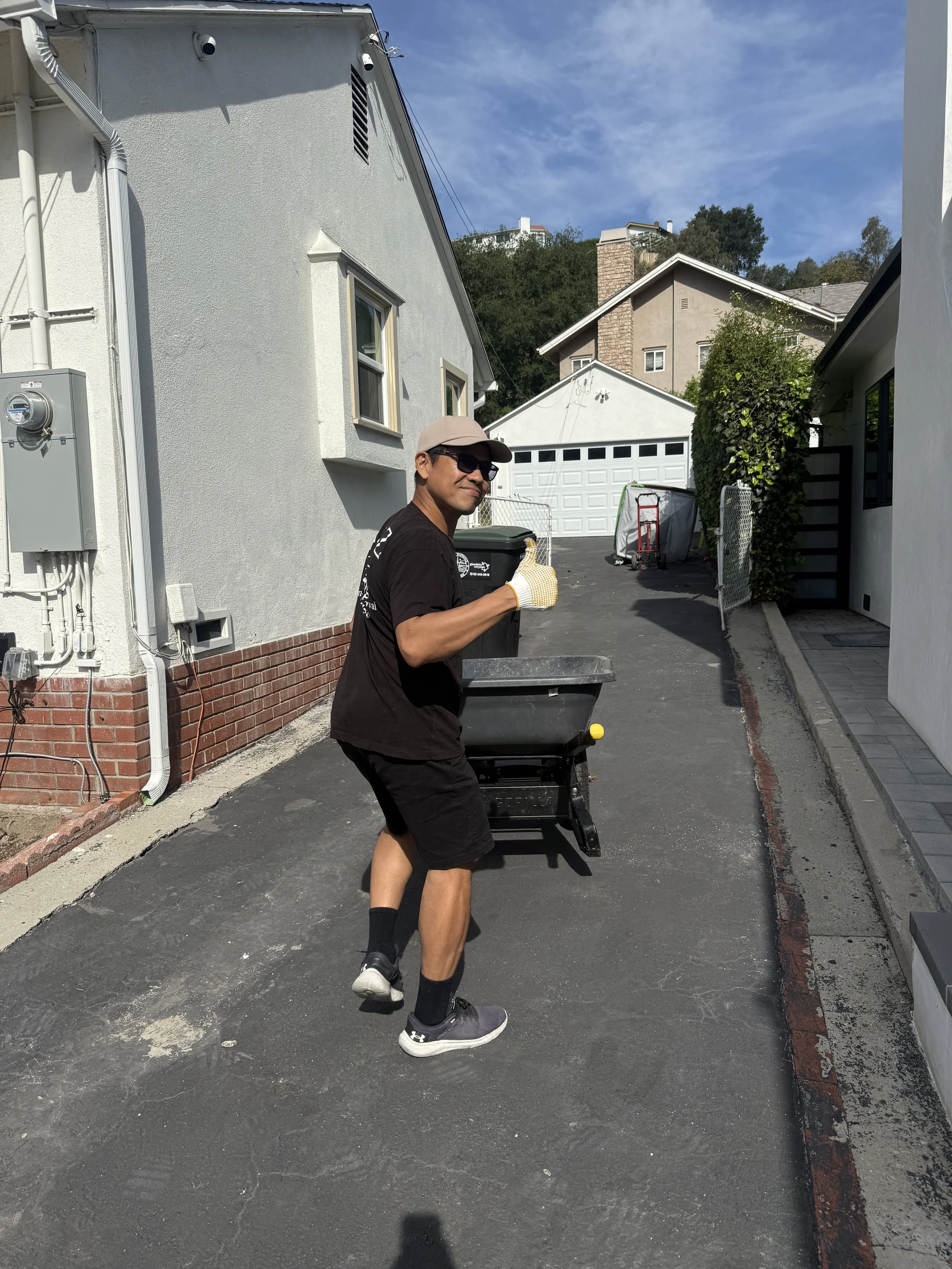 A to Z hauling crew member giving a thumbs up while walking down the driveway to pick up junk removal in Glendale,ca