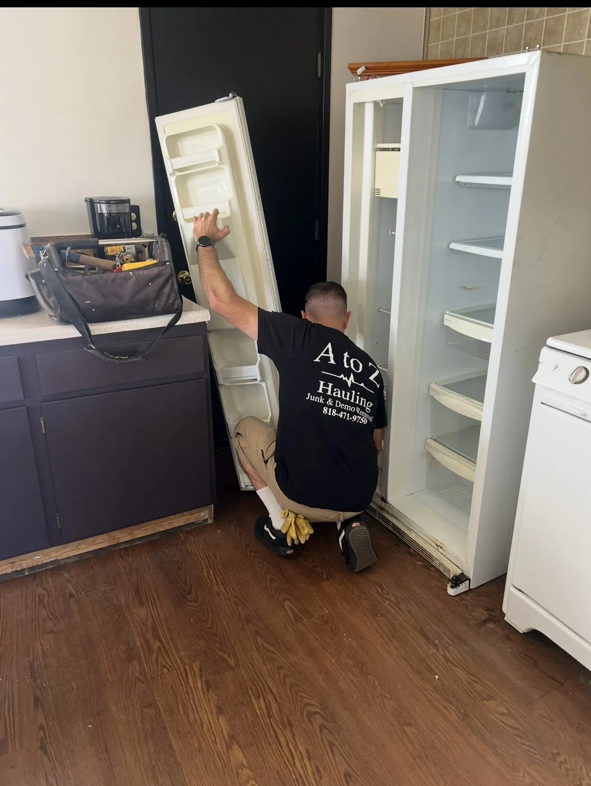 A to Z Hauling Junk Removal crew member removing a refrigerator 