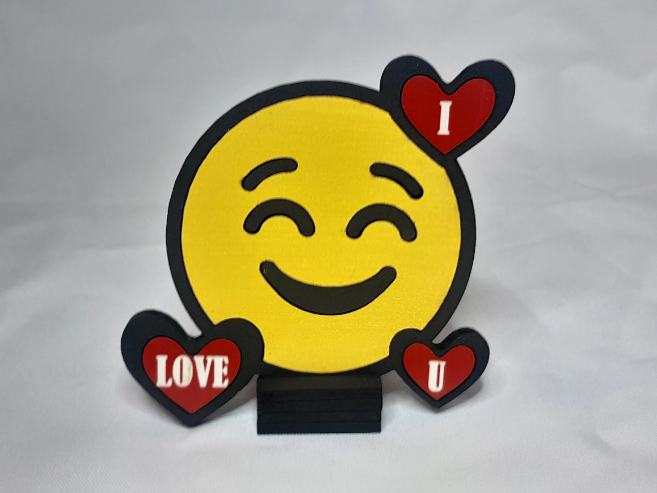 “Red heart emoji magnet with ‘I LOVE U’ text, laser‑cut painted wood with bold outlines, shown on a wooden display easel.”