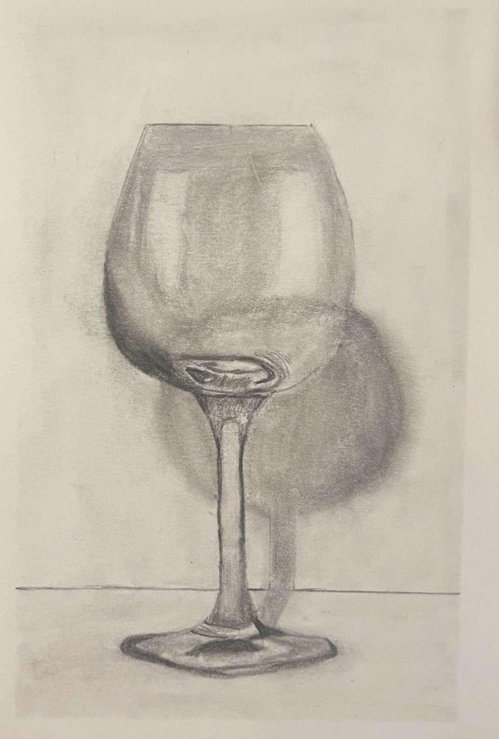 A pencil drawing of a wine glass with liquid inside, casting a shadow on the surface.