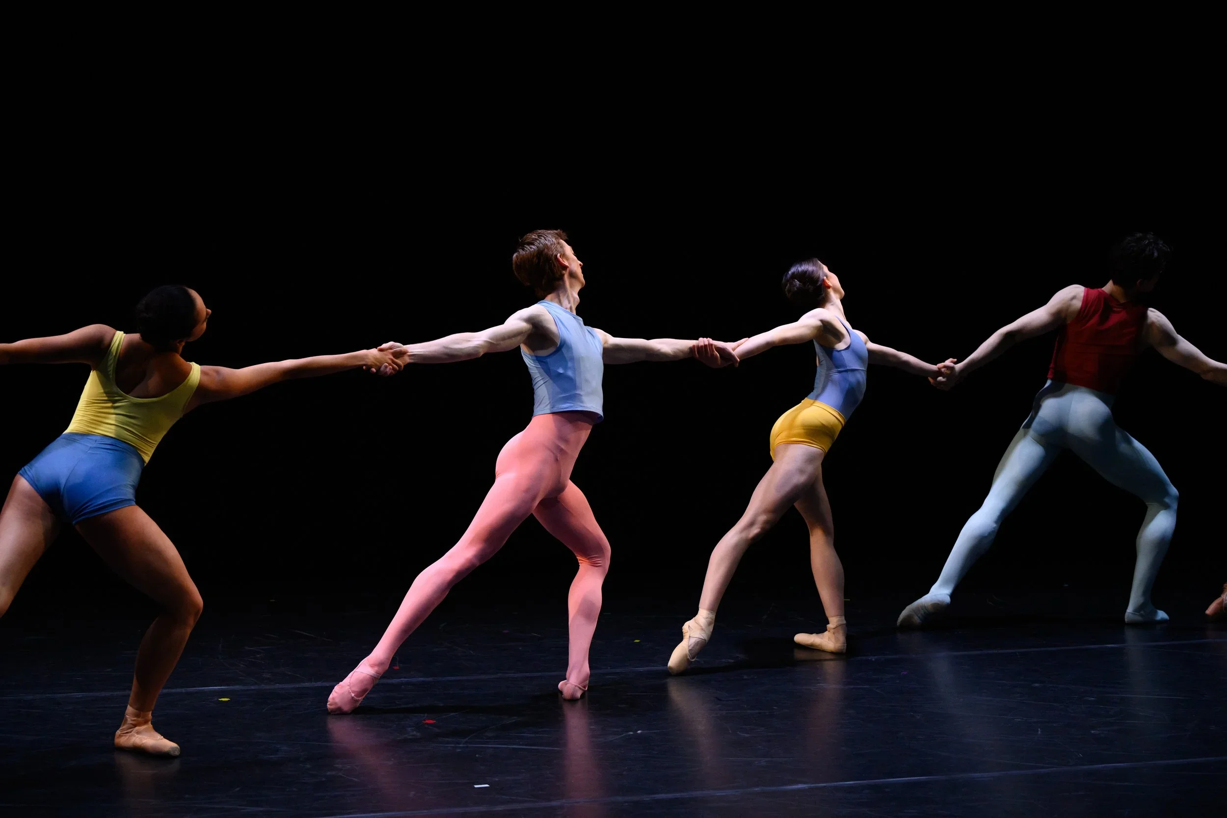 image of dancers in colourful costumes holding hands