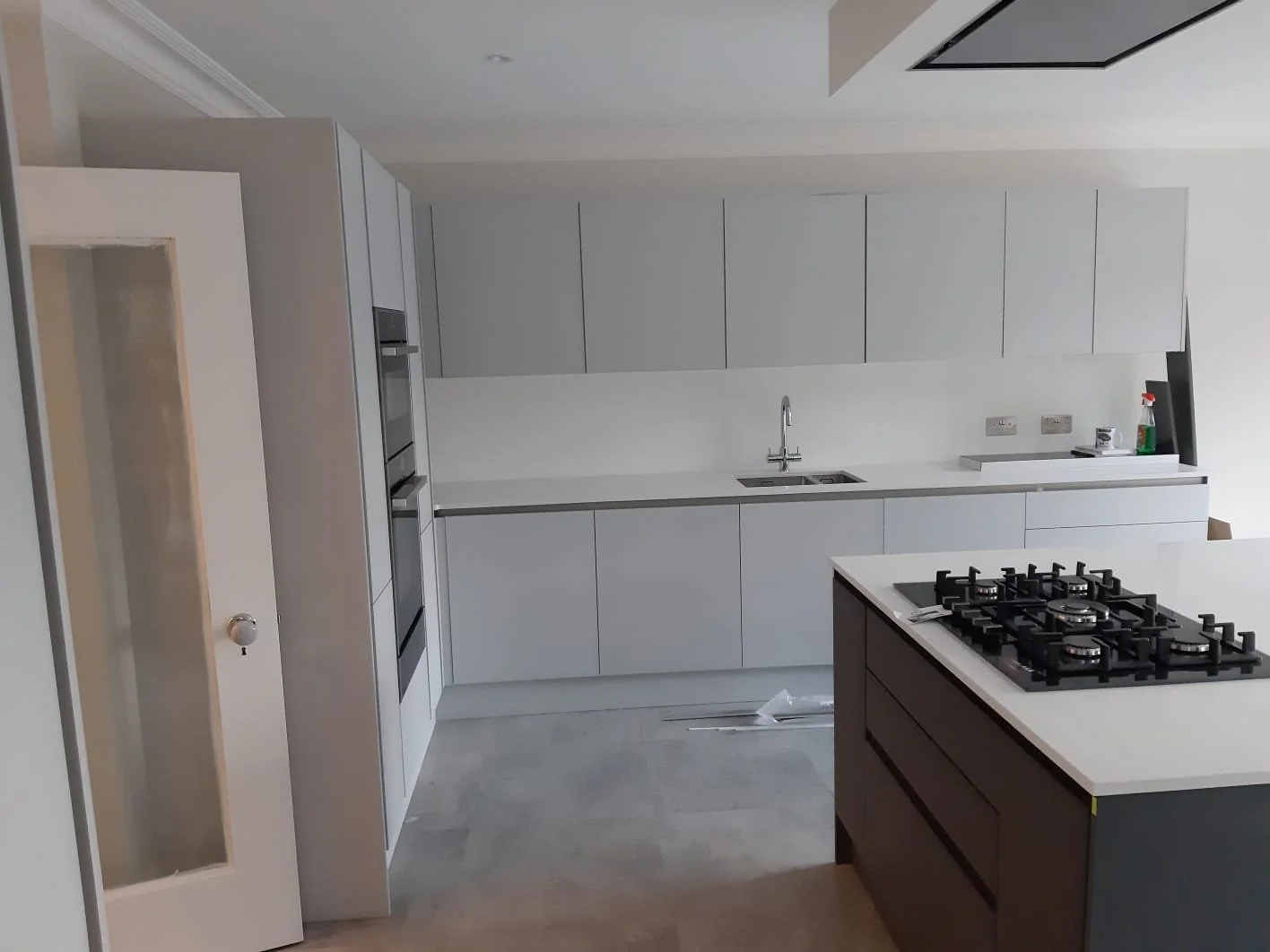 Before and after kitchen refurbishment transformation with new units and brighter space.