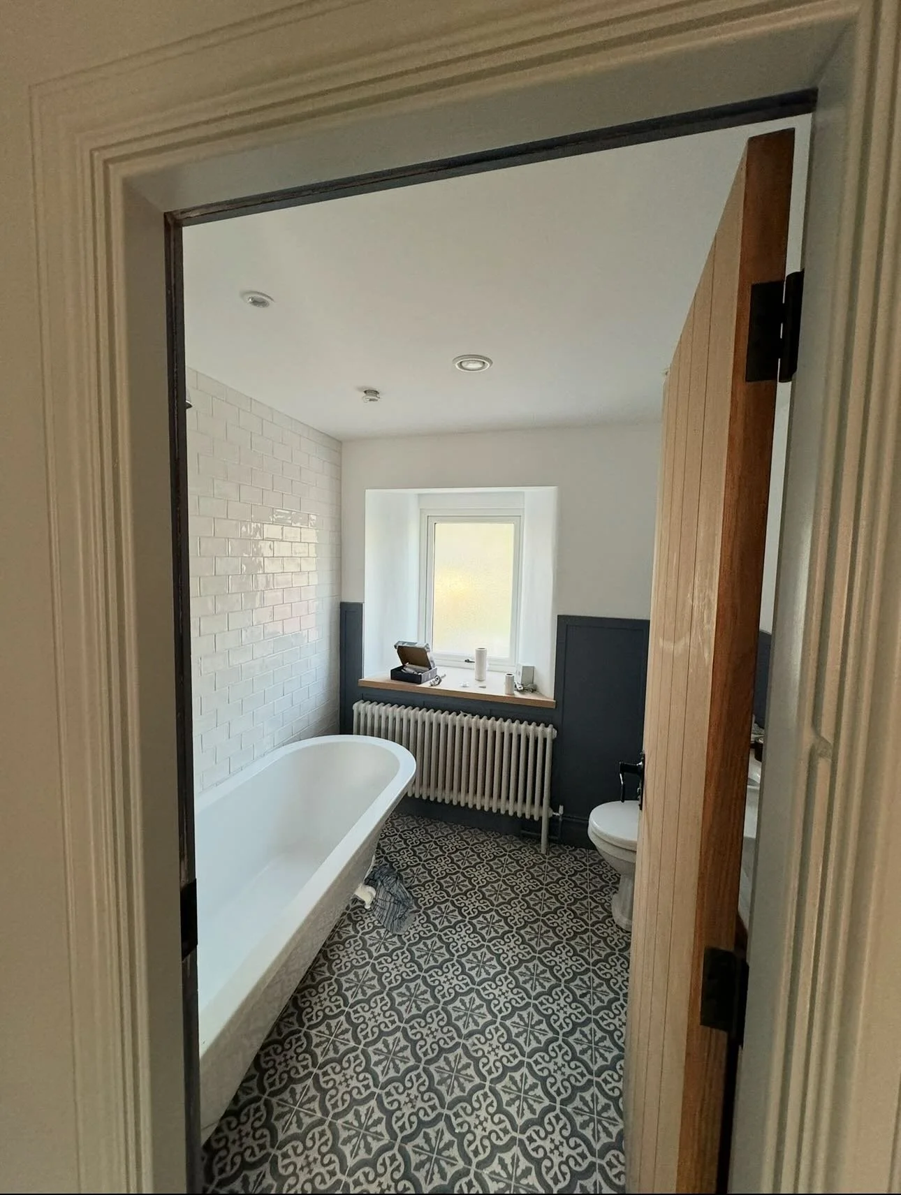 The family bathroom&rsquo;s makeover is complete, with blue woodwork adding a striking contrast to the white walls and fixtures.