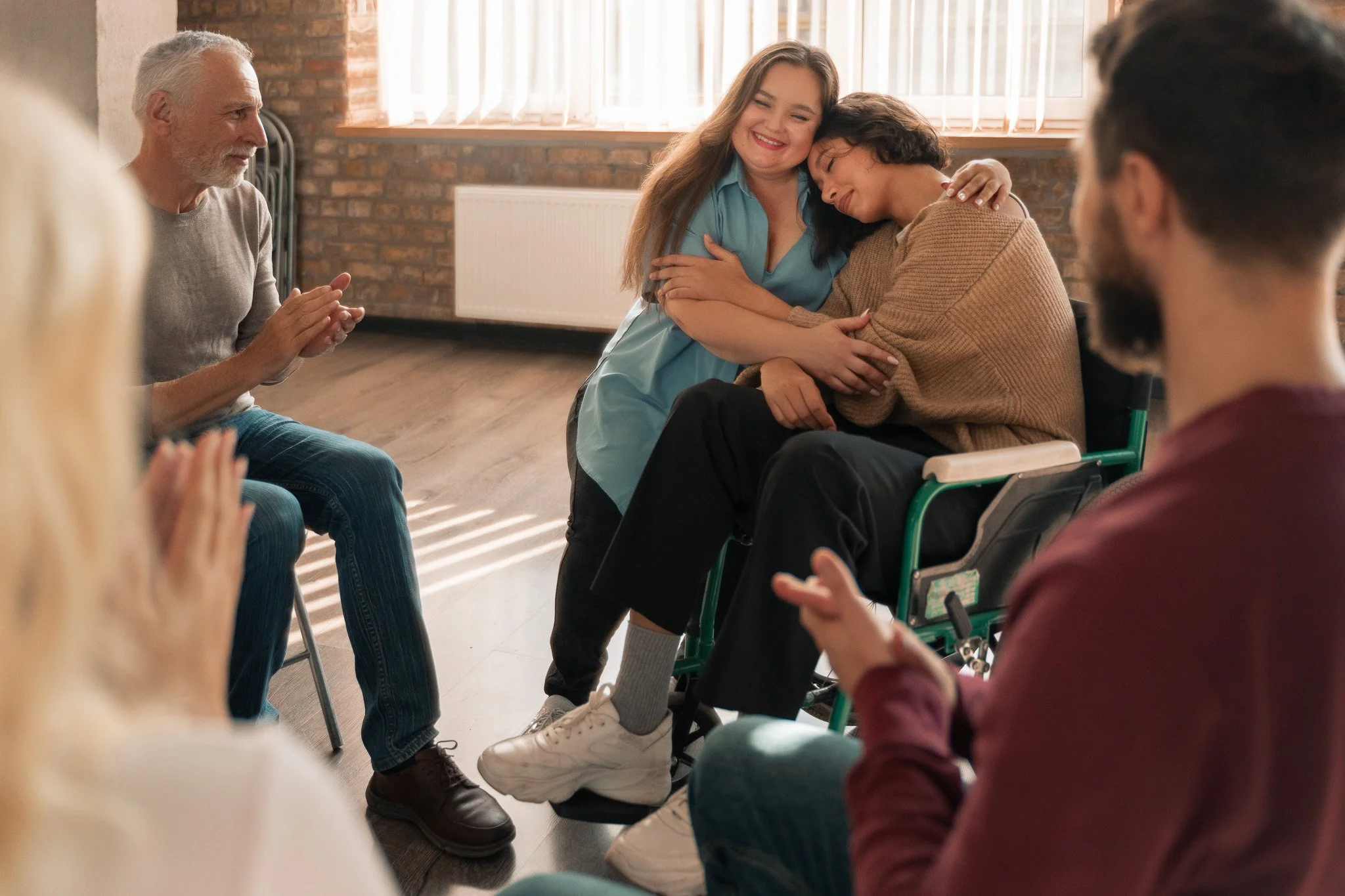 A group of people sitting in a healing circle sharing and going through grief as a community.