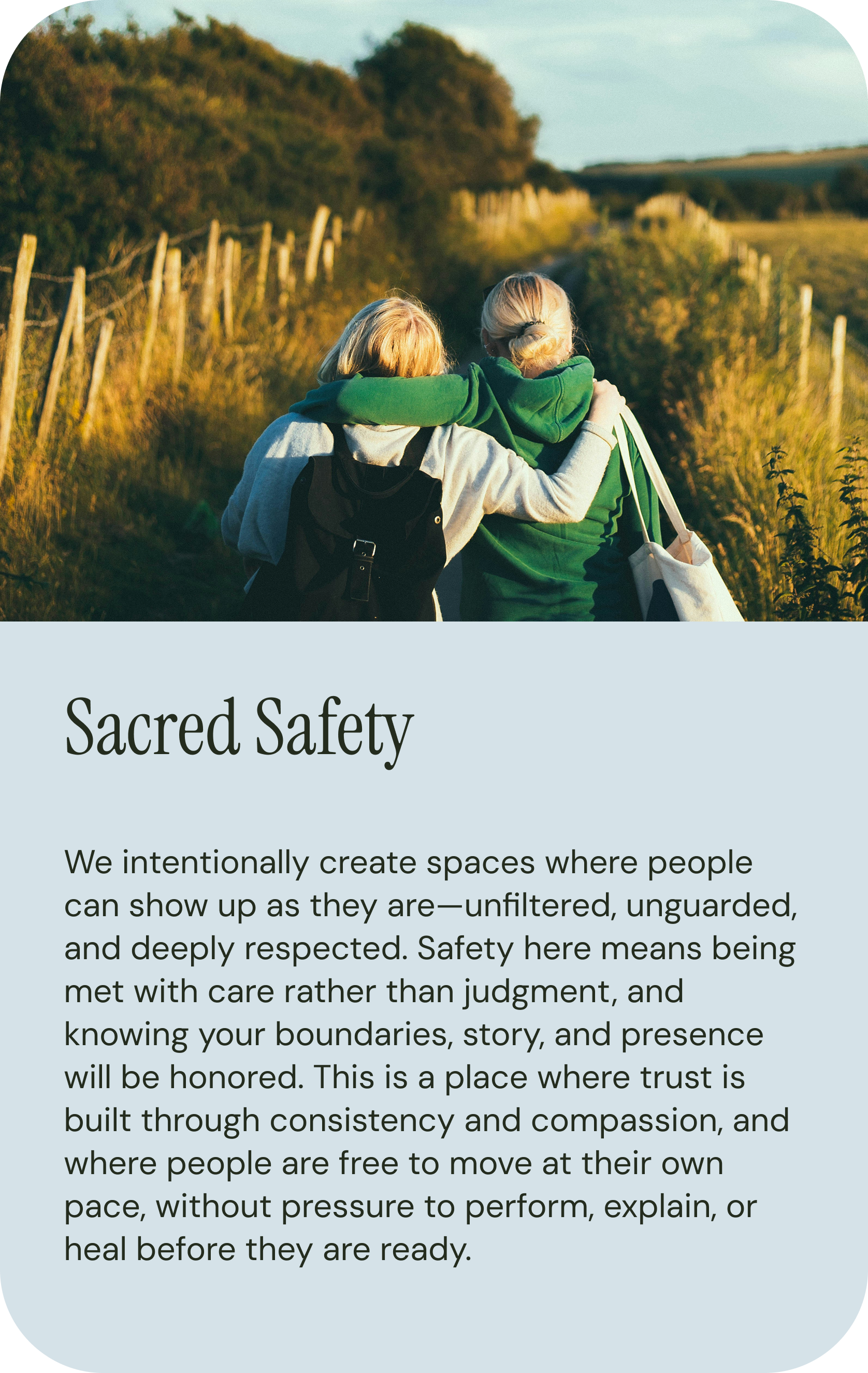 A photo of two women walking on a rustic path surrounded by nature during sunset, with one woman wrapping her arm around the other's shoulders.