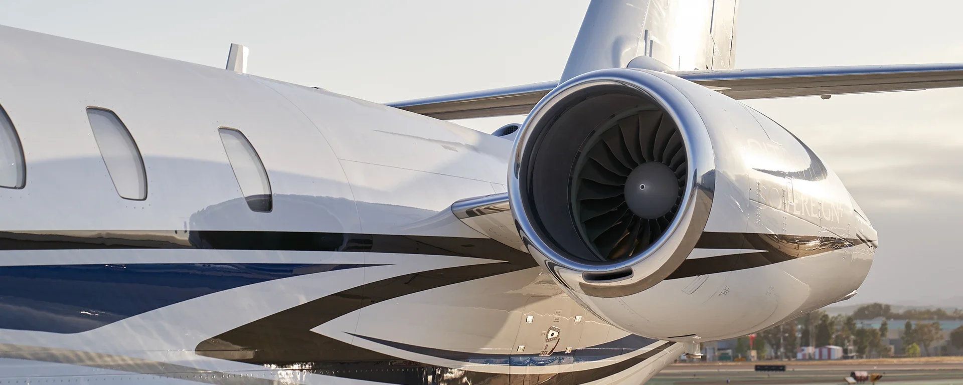 Close-up of a private jet's engine and fuselage on the tarmac.