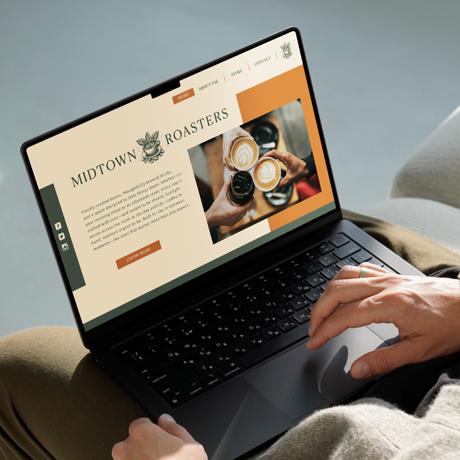 Person using a laptop with a website about Midtown Roasters coffee shop displayed on the screen, showing a hand holding coffee cups and a menu.