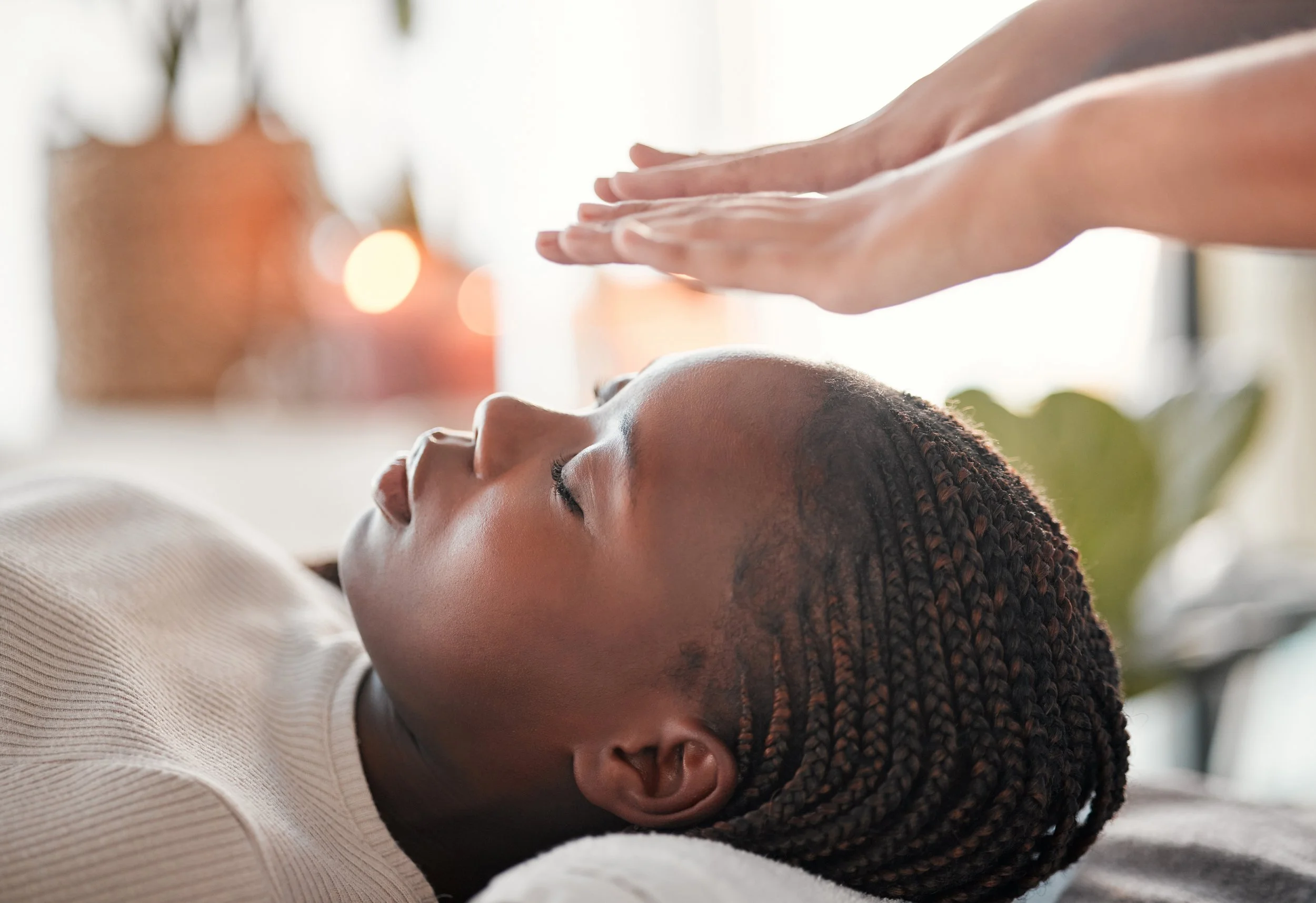 Woman receiving a forehead massage in a relaxing setting.