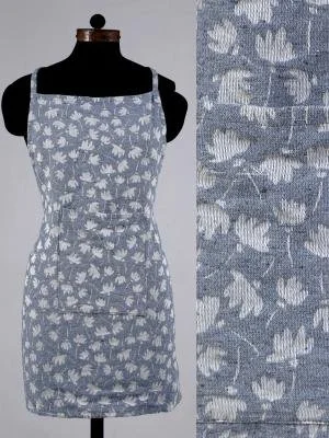 A light blue apron with a white floral pattern displayed on a black mannequin.