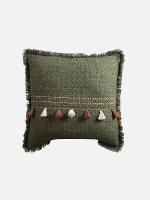 A decorative throw pillow with a green textured fabric and small tassels across the front.