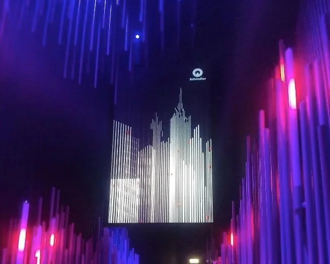 Colorful digital light display with vertical light bars and the Schneider logo at the top center.