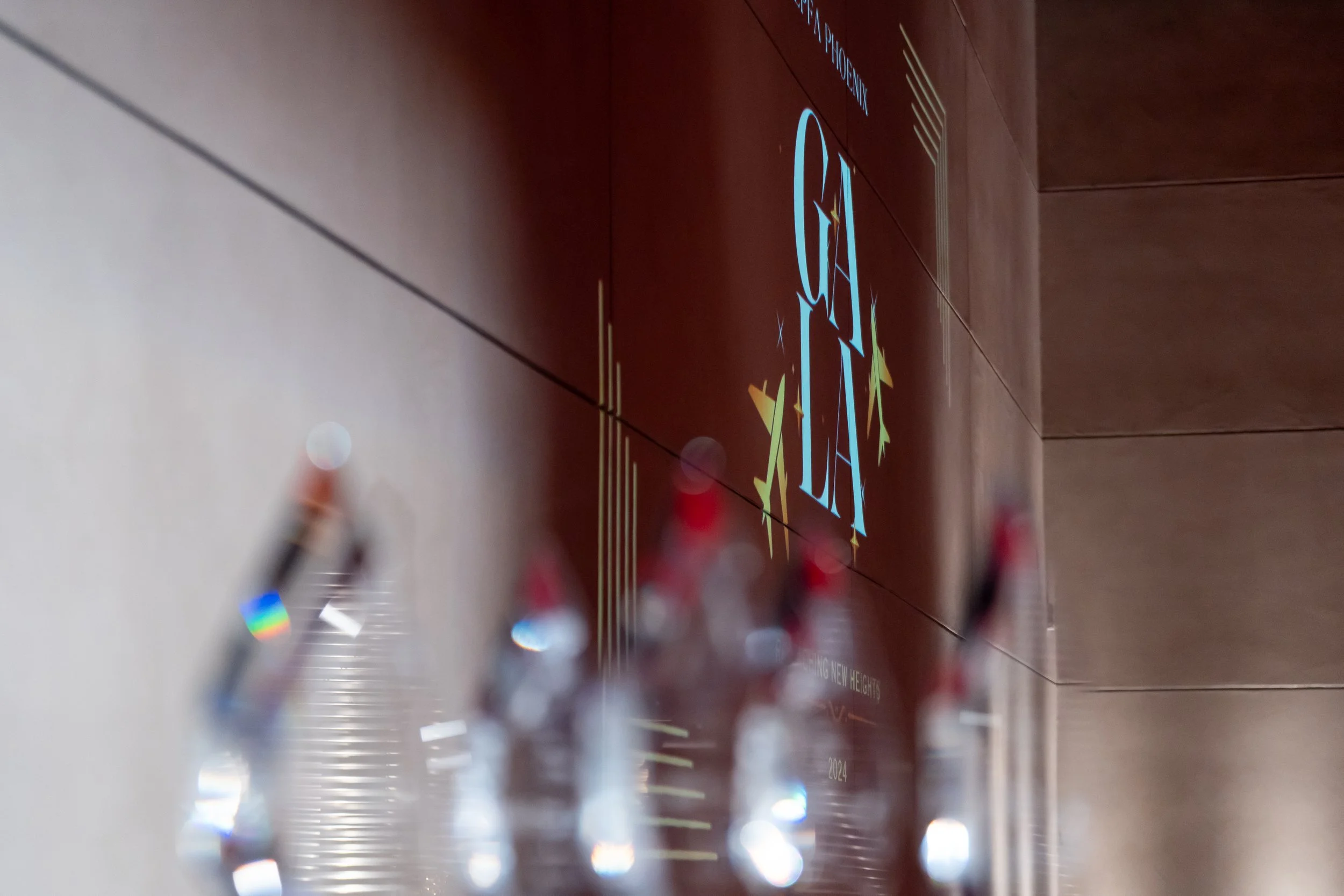 Close-up of a crystal trophy with a blurred background of a wooden wall and a digital sign.