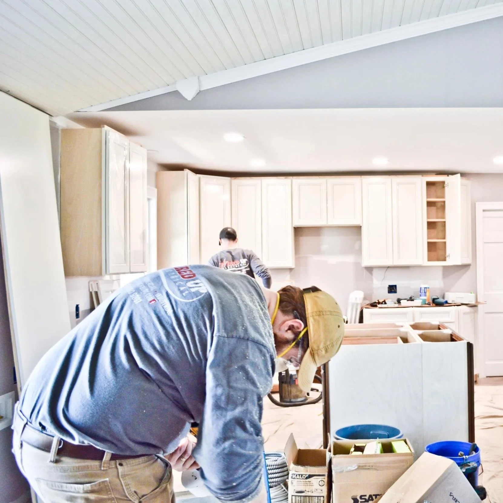 Professional electricians installing wiring during a home room addition renovation, preparing circuits, lighting, and outlets for safe long-term use.