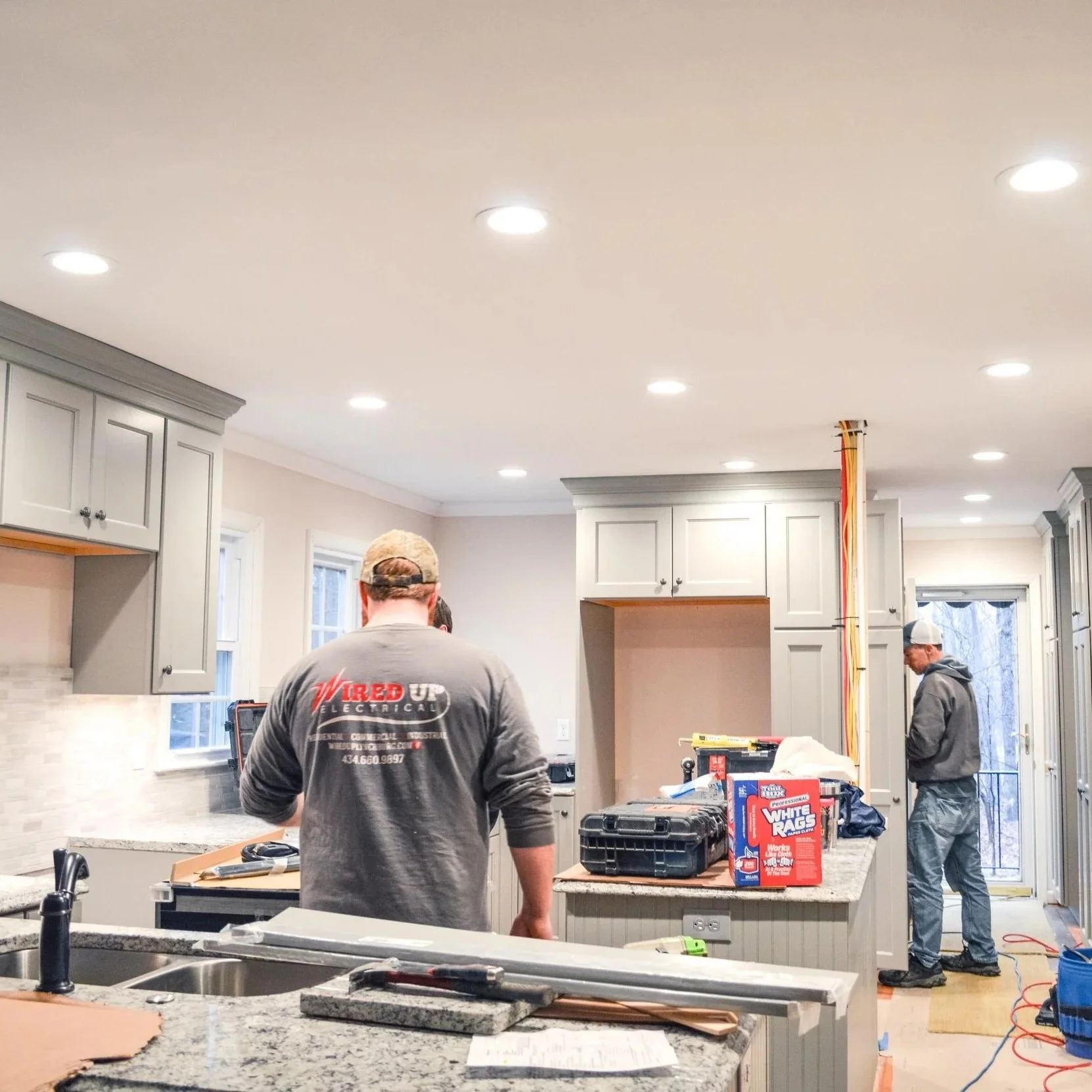 Electrician performing electrical troubleshooting and voltage testing inside a residential electrical panel in a Lynchburg, VA home
