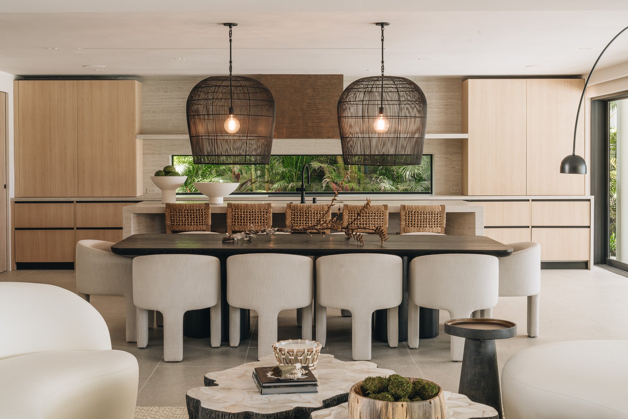 Light laminate millwork kitchen with a backsplash window. Huge basket pendants over dining table.