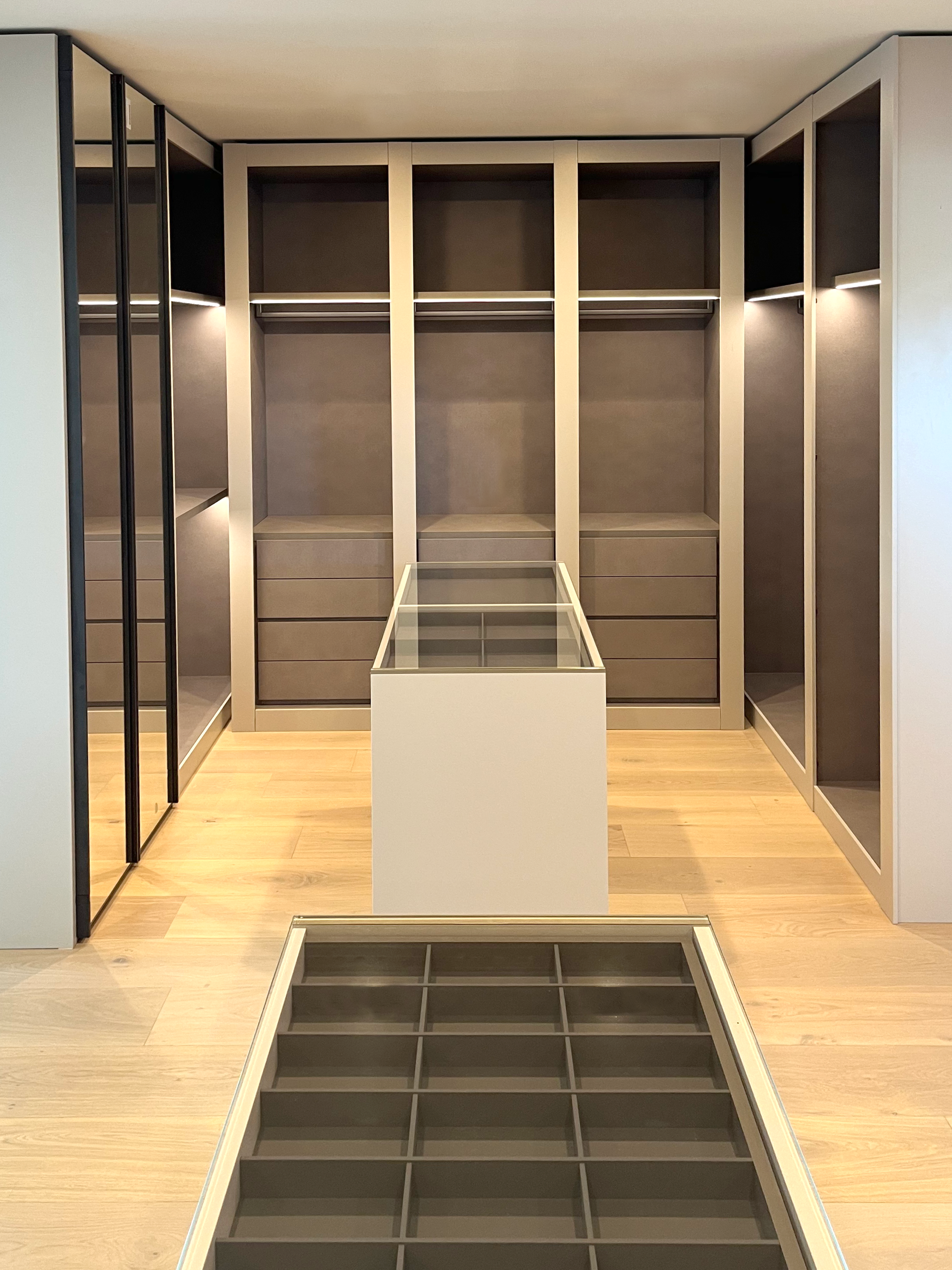 Closet with integrated lighting and islands on two sides.