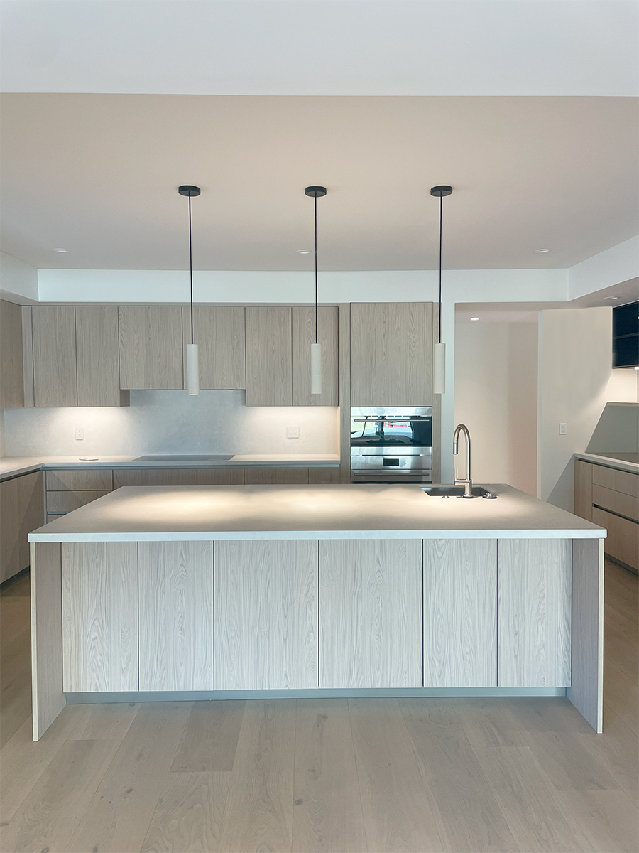 This Kitchen features light oak inspired laminate millwork from Italy along with light toned porcelain countertops giving an overall Japandi feel.