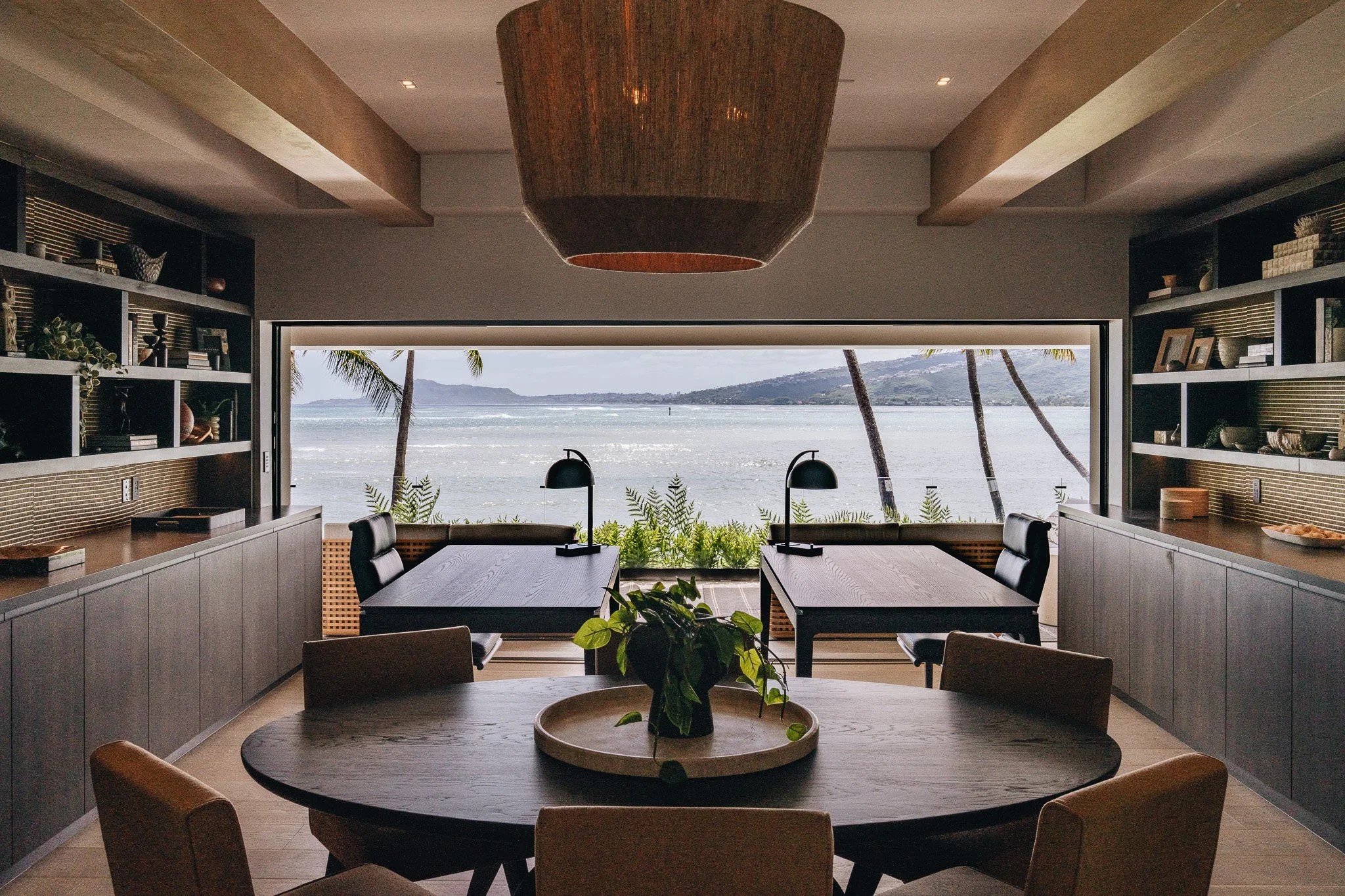 Home office with a beautiful ocean view. Sides of the office are flanked by integrated bookshelves and dark wood look laminate Italian cabinets.