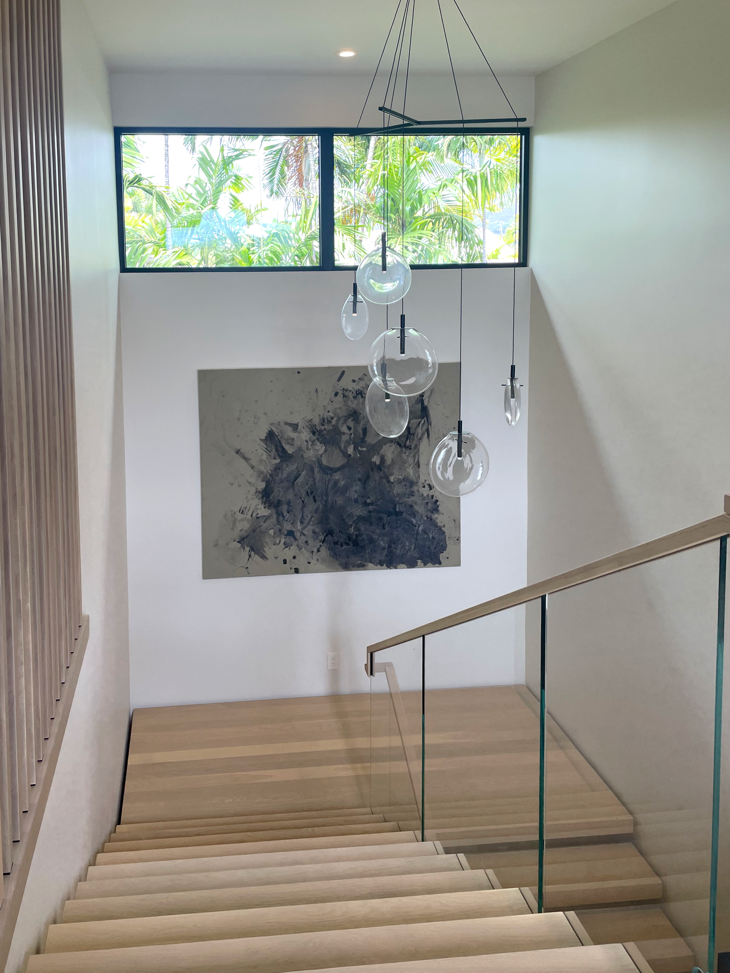 Light oak stairway with abstract art on wall.
