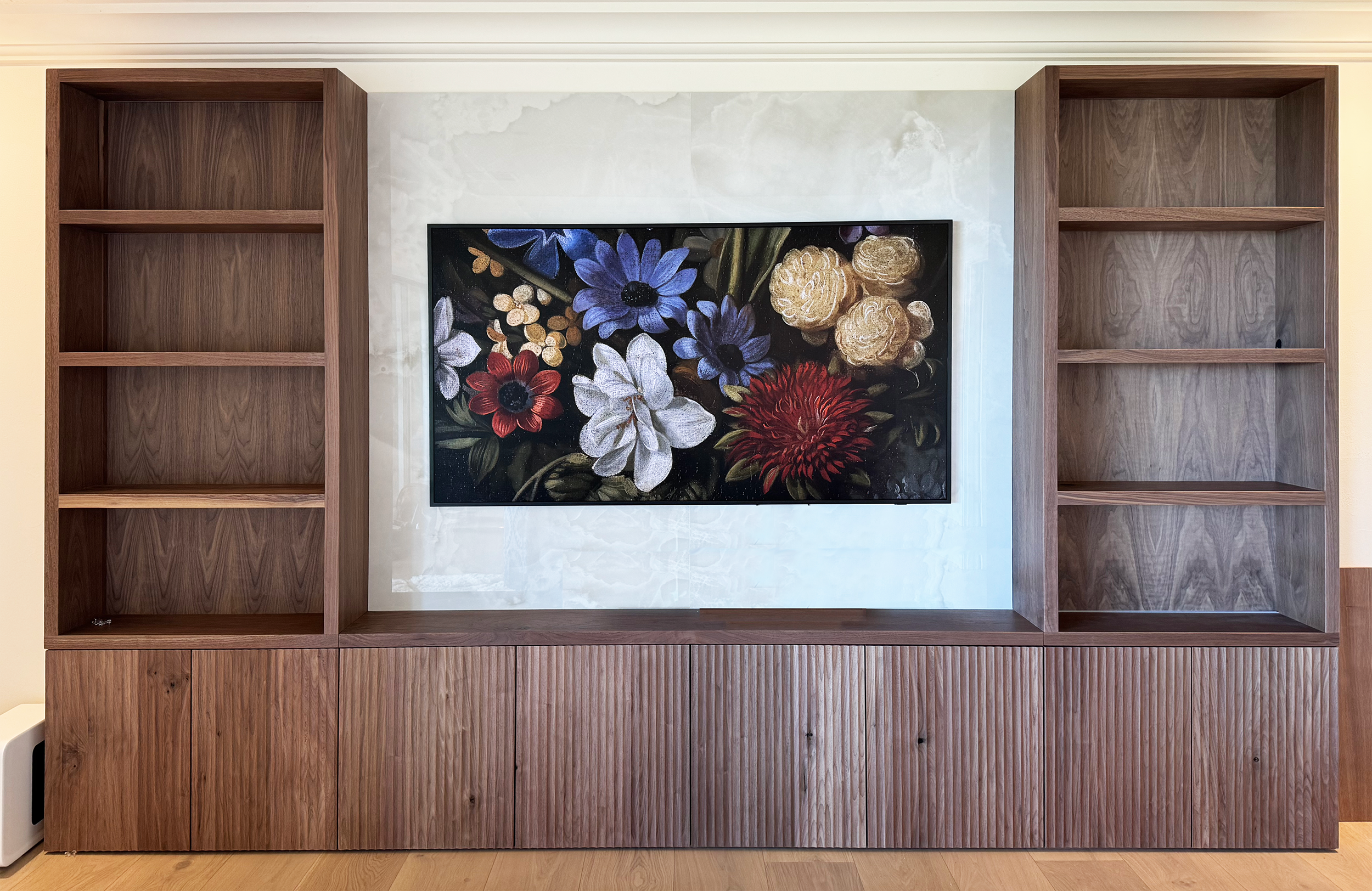 This media center features solid walnut open shelving with fluted door fronts created by a woodworker local to Oahu.