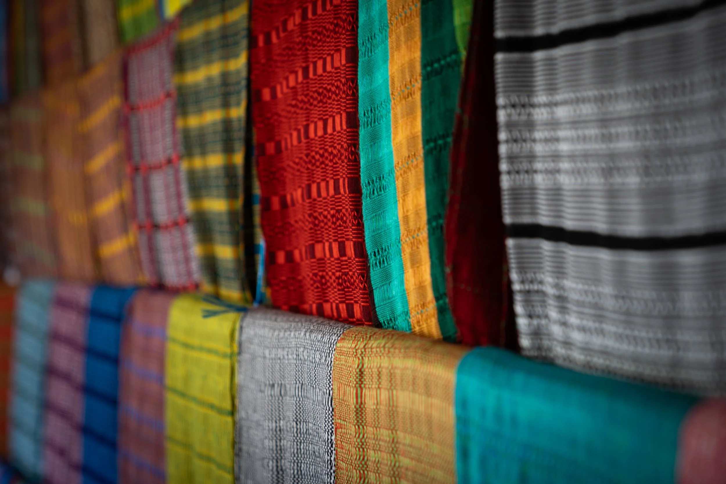 Close-up of colorful woven fabric with various geometric patterns and stripes.