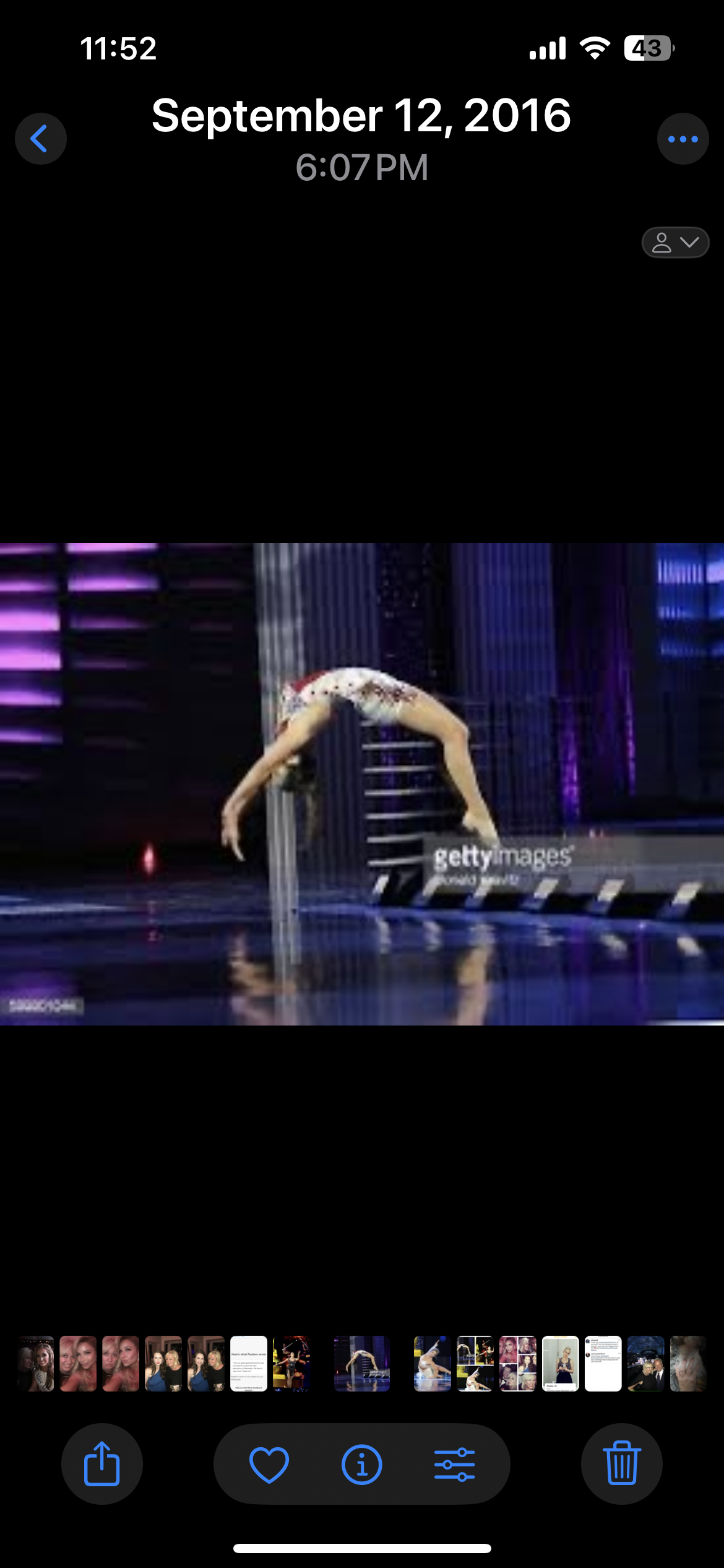 A gymnast performing a backbend on a stage with purple lighting and vertical light accents in the background.