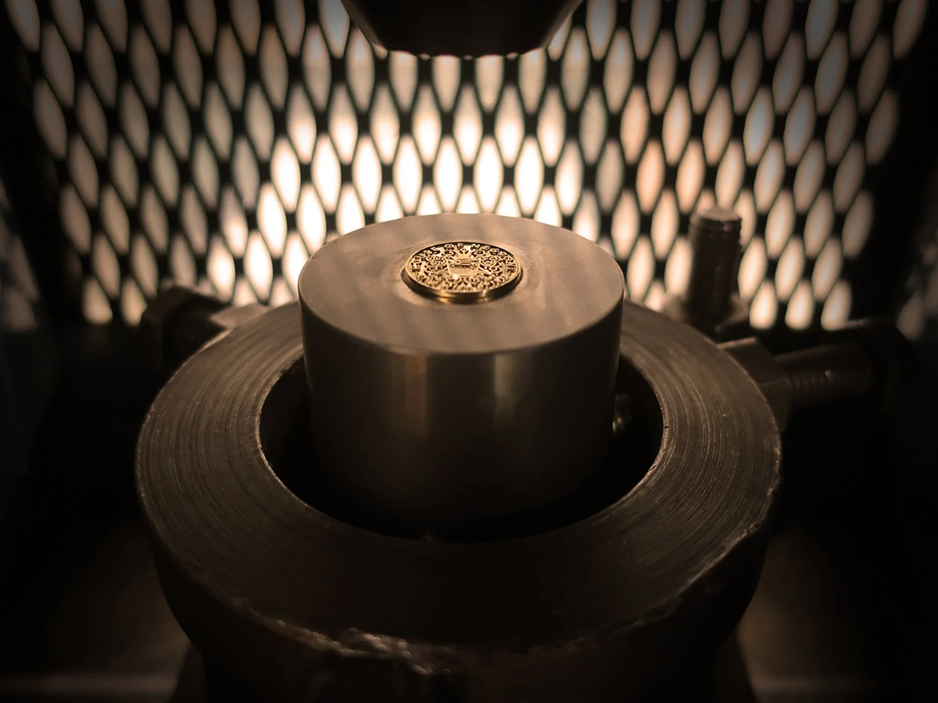 A manufacturing image showing a gold cufflink being crafted