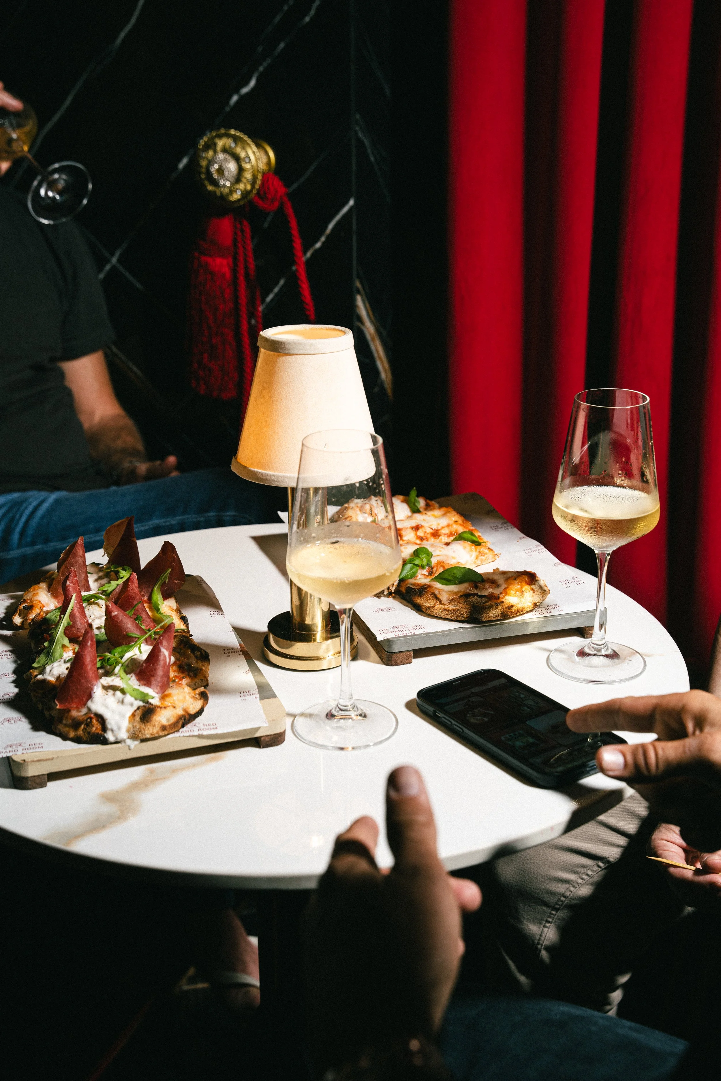 Friends drinking wine and eating pizza