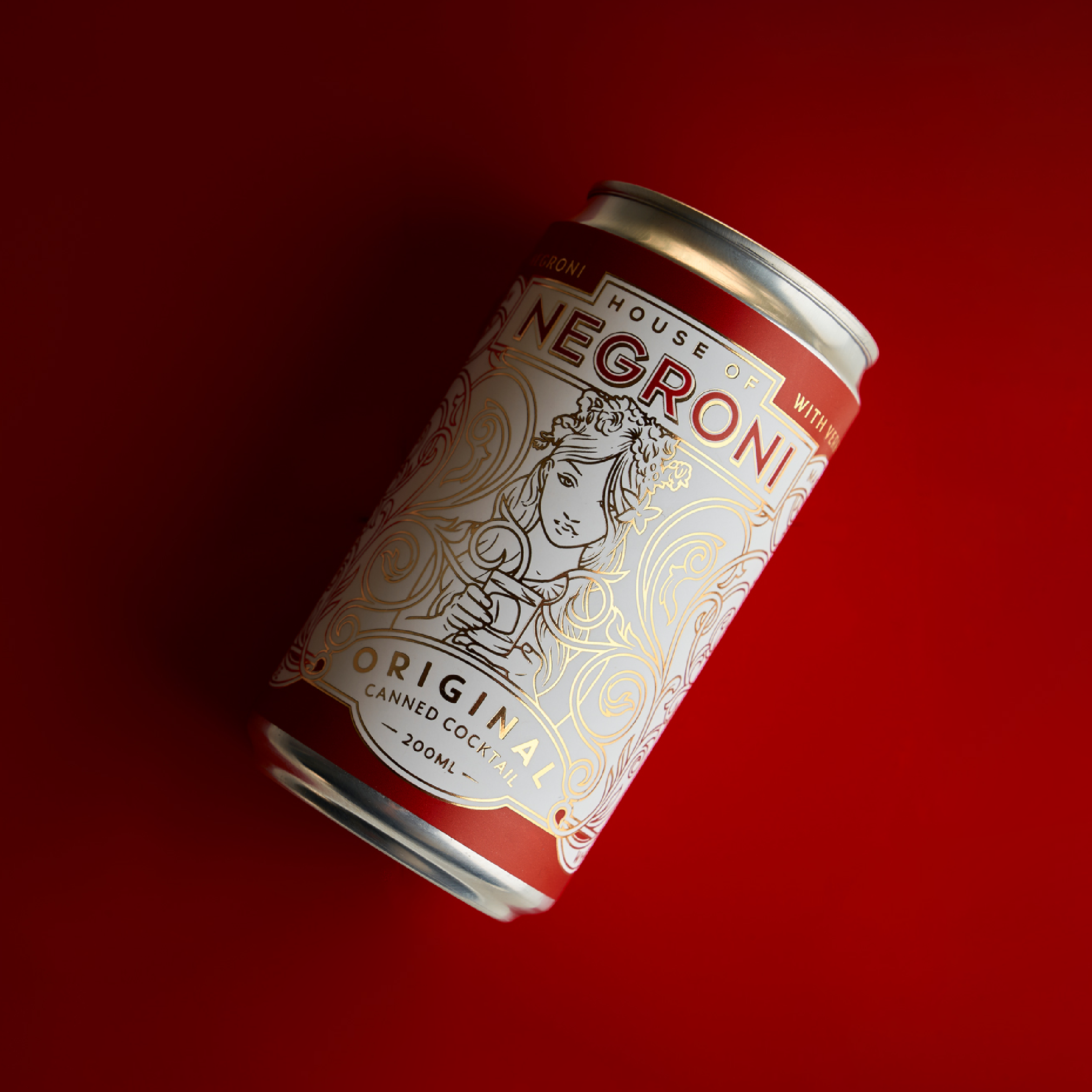 A can of House of Negroni original canned cocktail, with a red and white label, featuring an illustration of a woman holding a cocktail glass, set against a red background.
