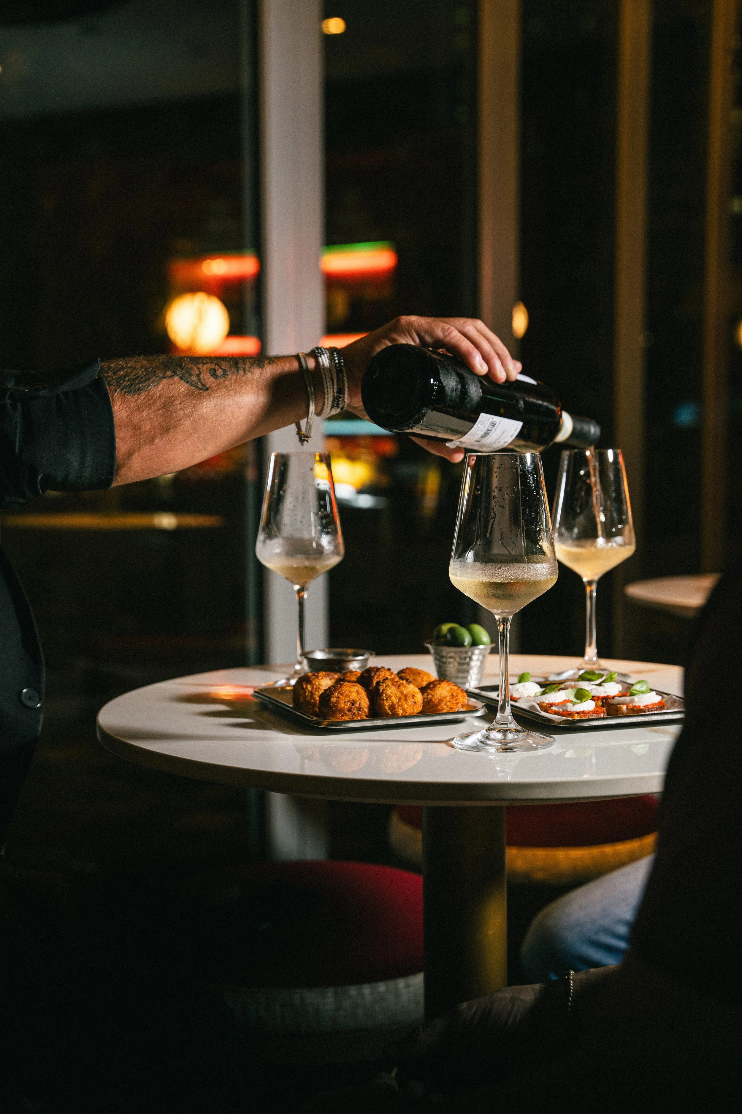 Pouring white wine and eating snacks