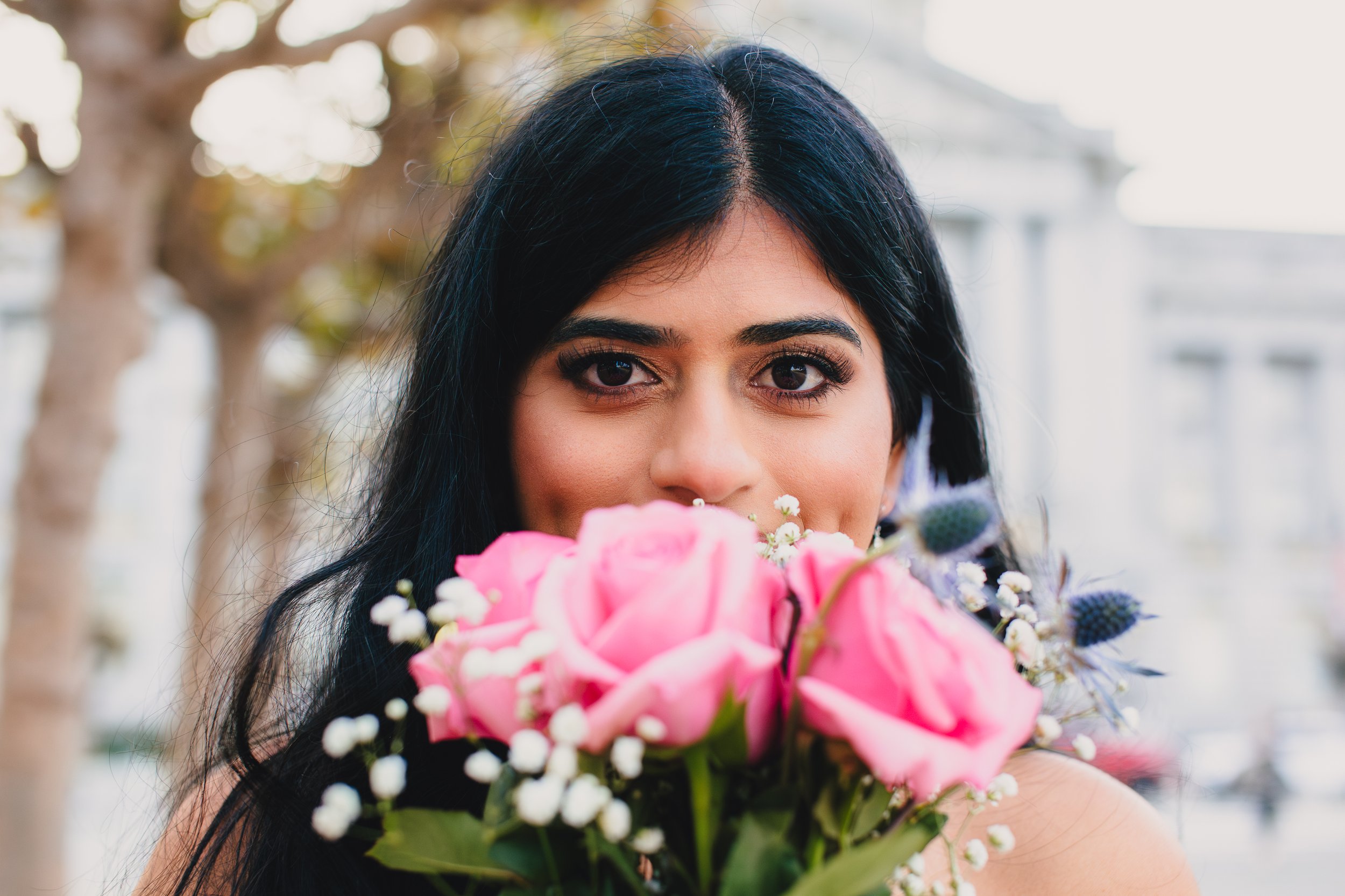 Bride with a bouquet in front of San Francisco City Hall