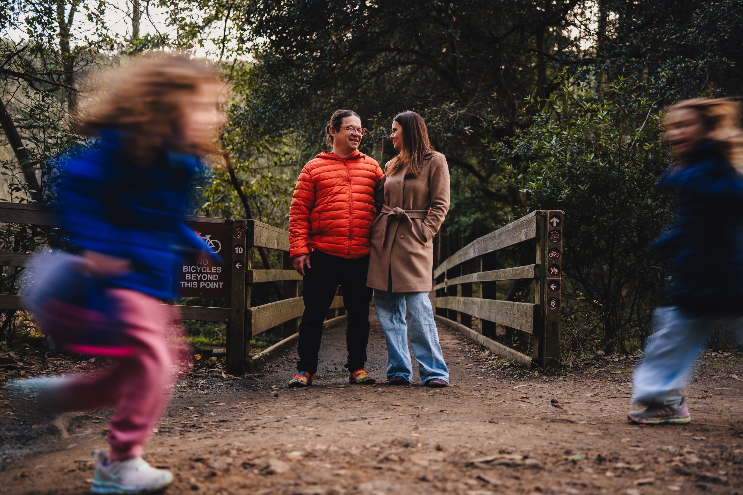 Kids running in front of their parents in Tilden Park in Berkeley