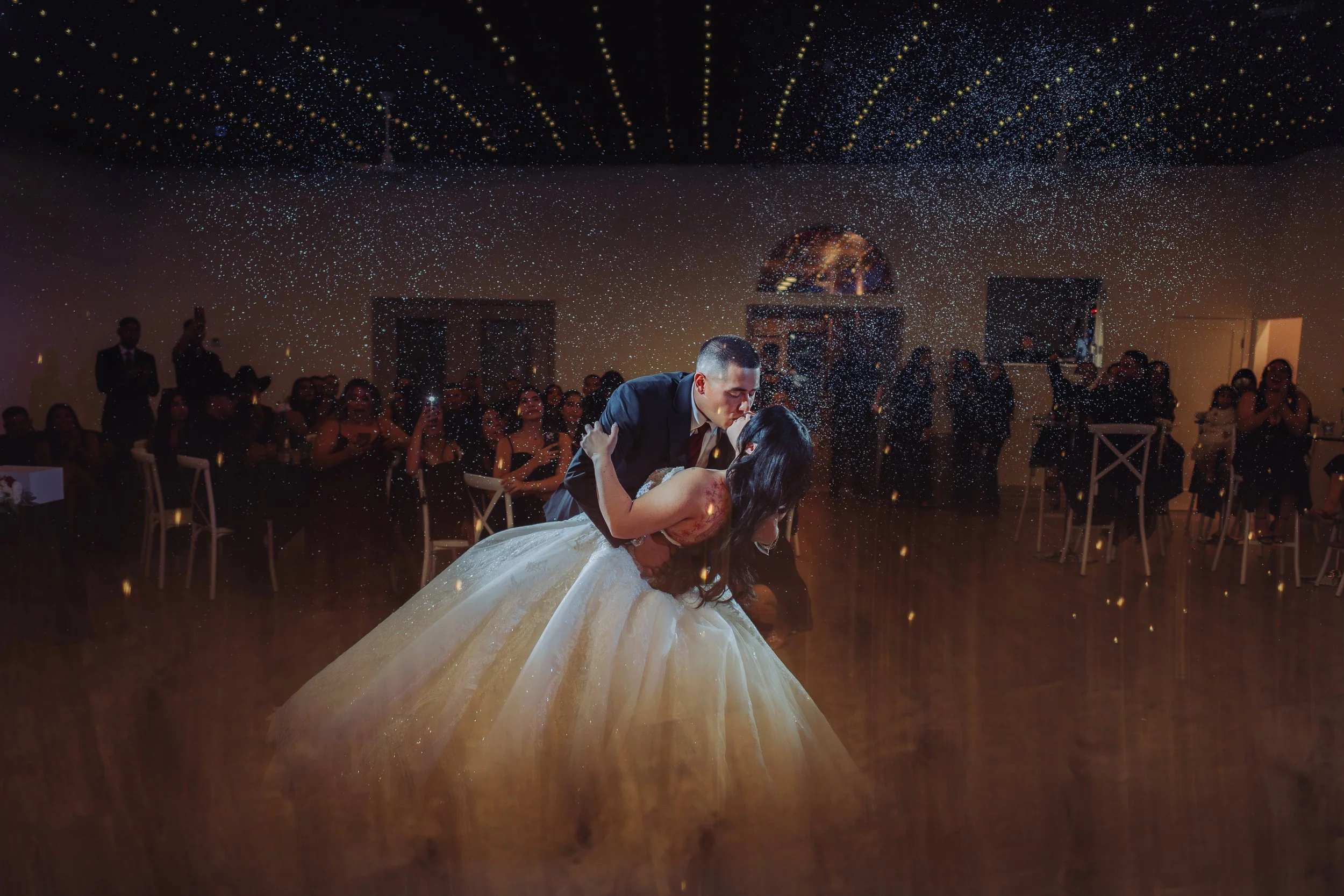 couple kissing during their first dance with mist and reflections