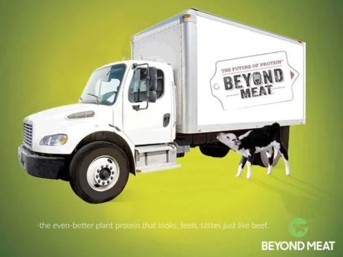 White delivery truck with Beyond Meat logo on the side, and a cow standing next to it, against a green background.