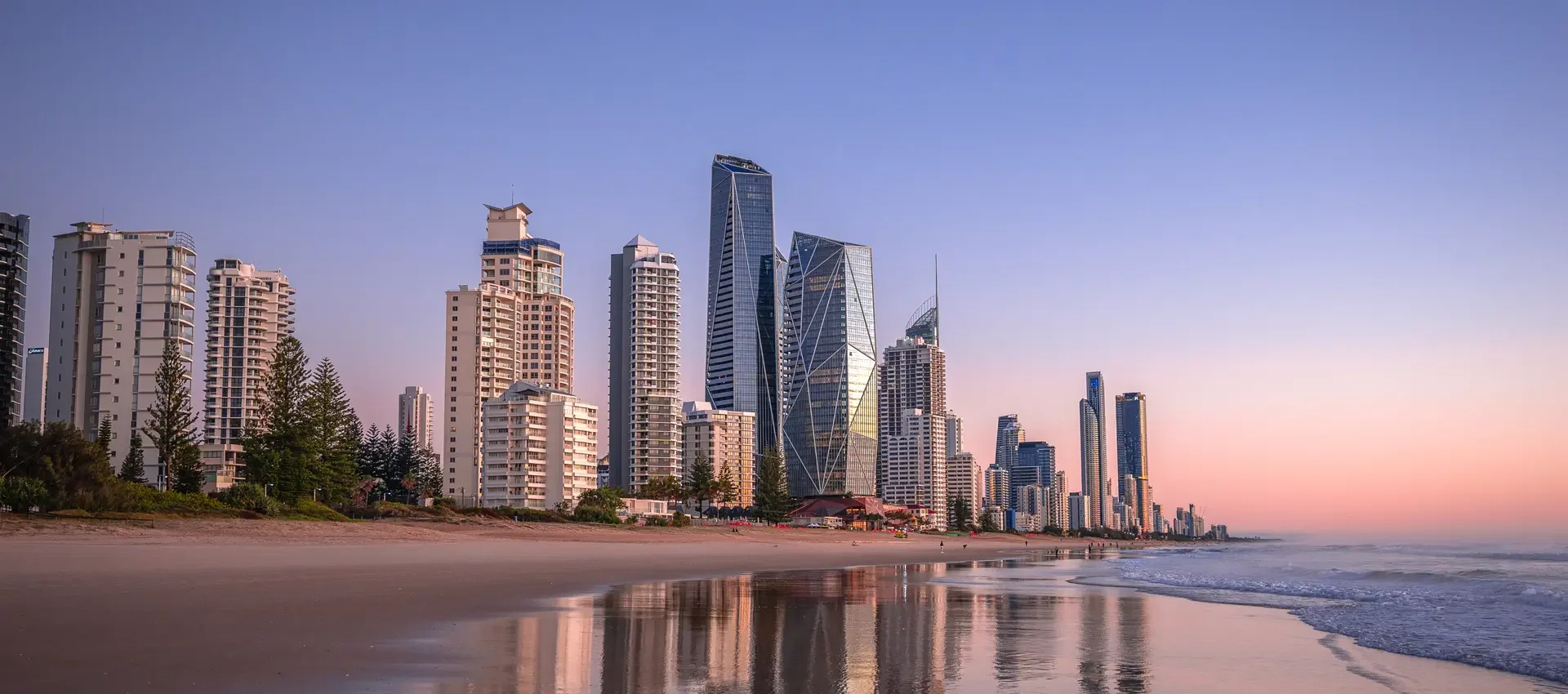 Image show the Gold Coast city skyline at dawn with a clear colourful sky.