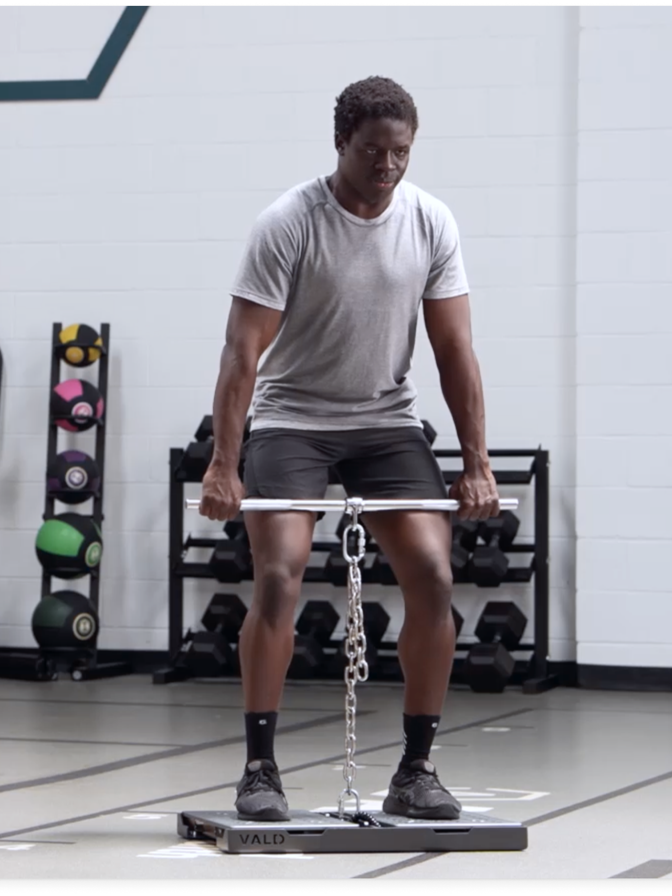 A man with low back pain doing an isometric mid thigh pull on force plates to improve exercise tolerance.