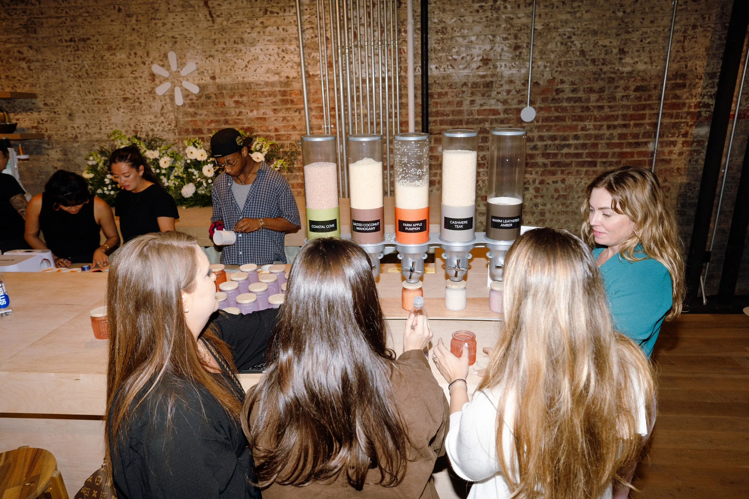 Guests engaged in personalized experiences like candle making, mug pressing, and napkin embroidery