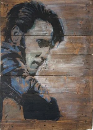 Street art of a young man with slicked-back hair, painted on wooden planks.