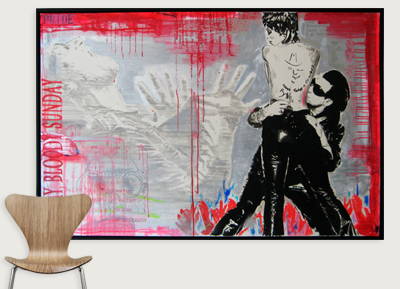A mixed media artwork featuring two figures with sunglasses, one sitting on the other's lap, against a colorful background with handprints and text reading 'PRIDE' and 'SUNDAY'.