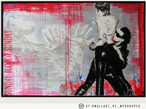Street art graffiti mural depicting a topless man with tattoos on his back and a woman wearing sunglasses, both standing with a red background and abstract designs.
