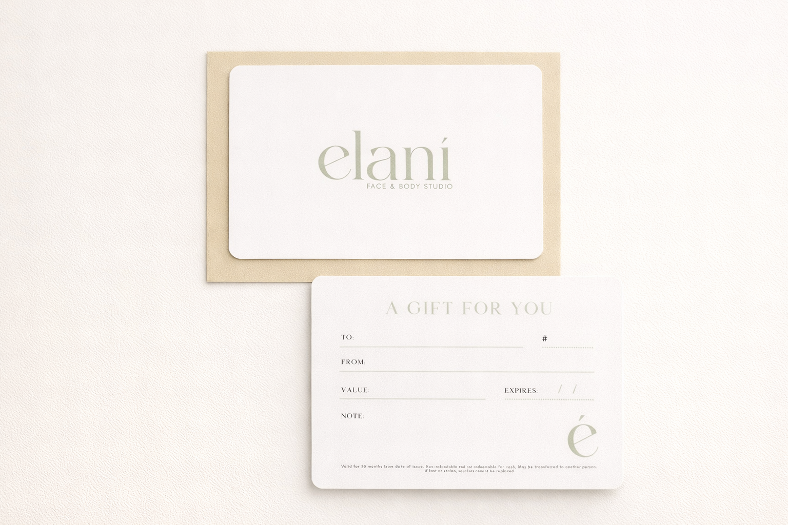 A gift card and note from Elani Face & Body Studio, with a beige envelope. The card says 'A GIFT FOR YOU' and has spaces for recipient, sender, value, expiration date, note, and a small logo with a stylized 'é'.