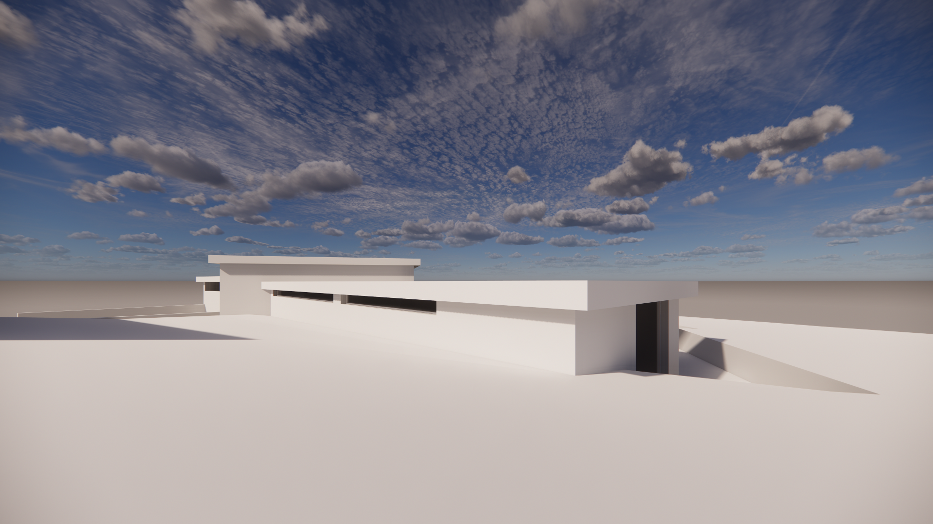 A modern white building with flat roofs and horizontal black windows under a cloudy blue sky.