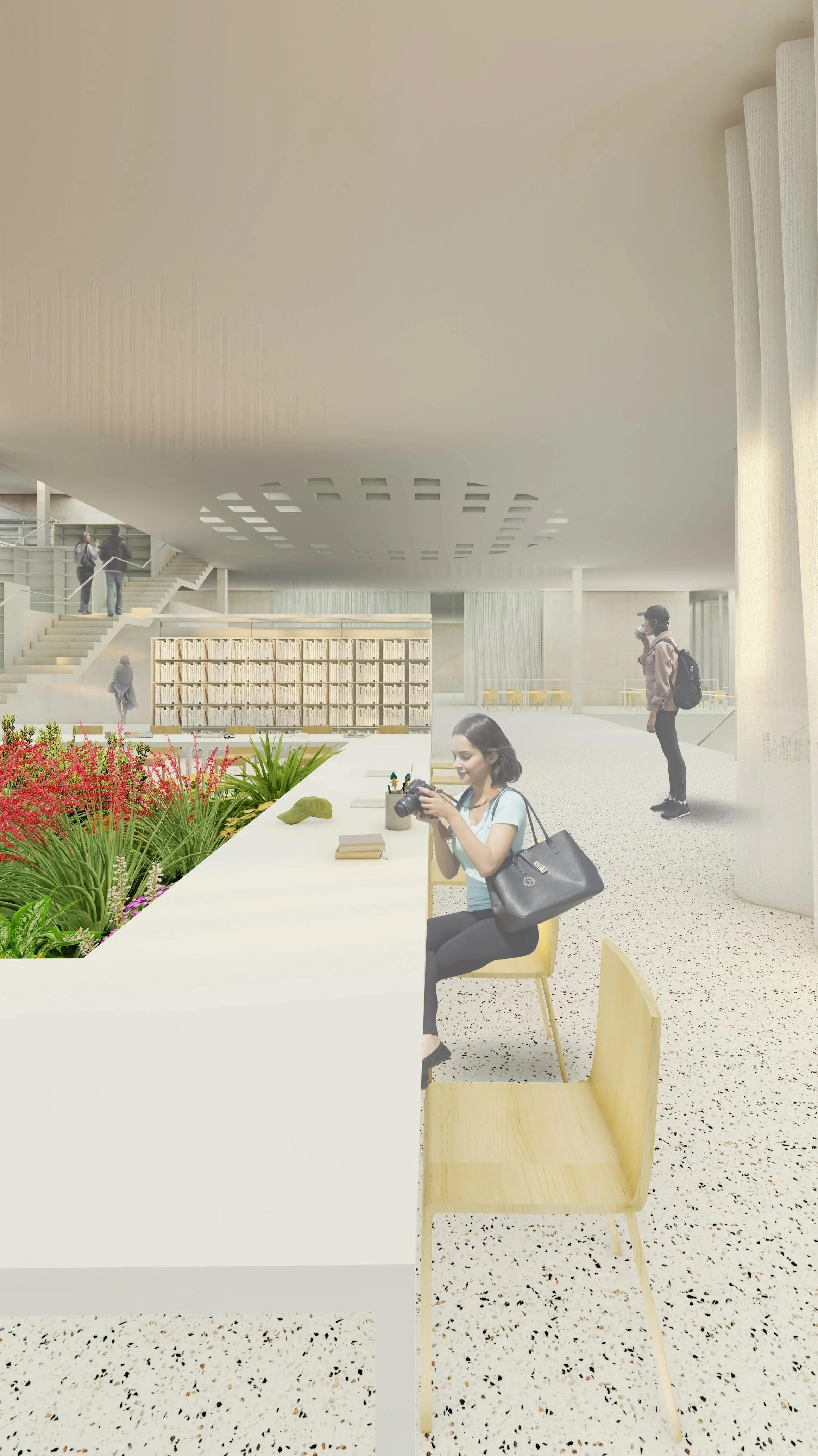 A woman sitting at a white table in a modern library or community space, looking at a camera. There are plants and gardening tools on the table, and other people are in the background, some standing on stairs and others walking.