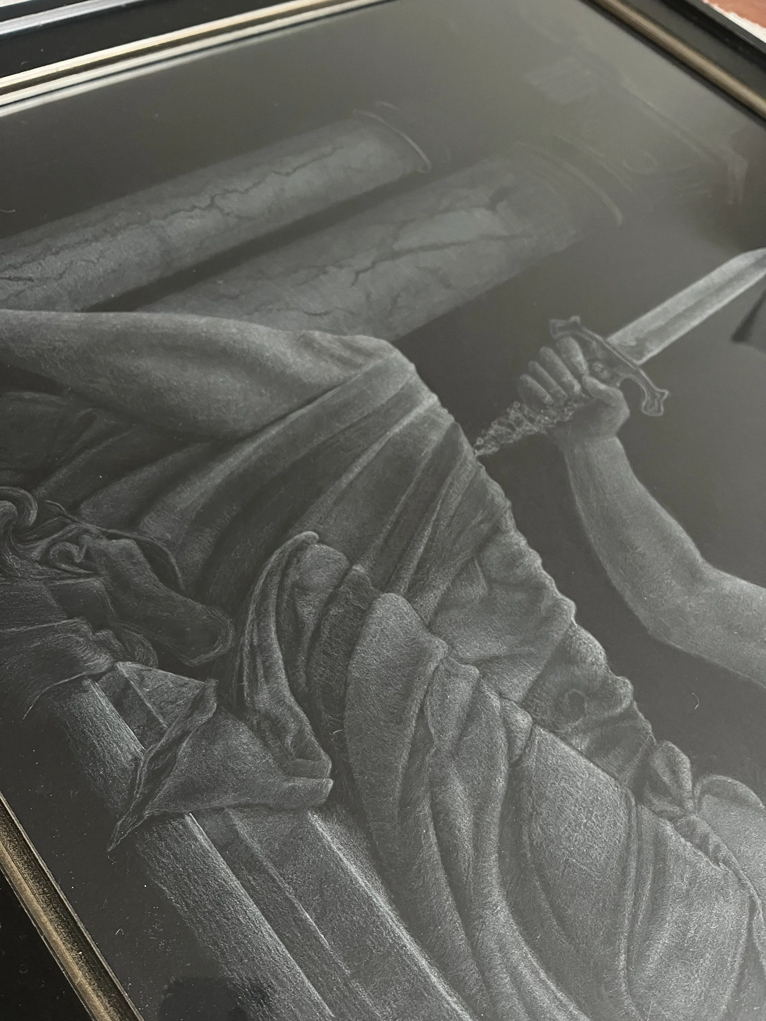 Black fabric cloth with detailed threading and folds, placed on a black surface.